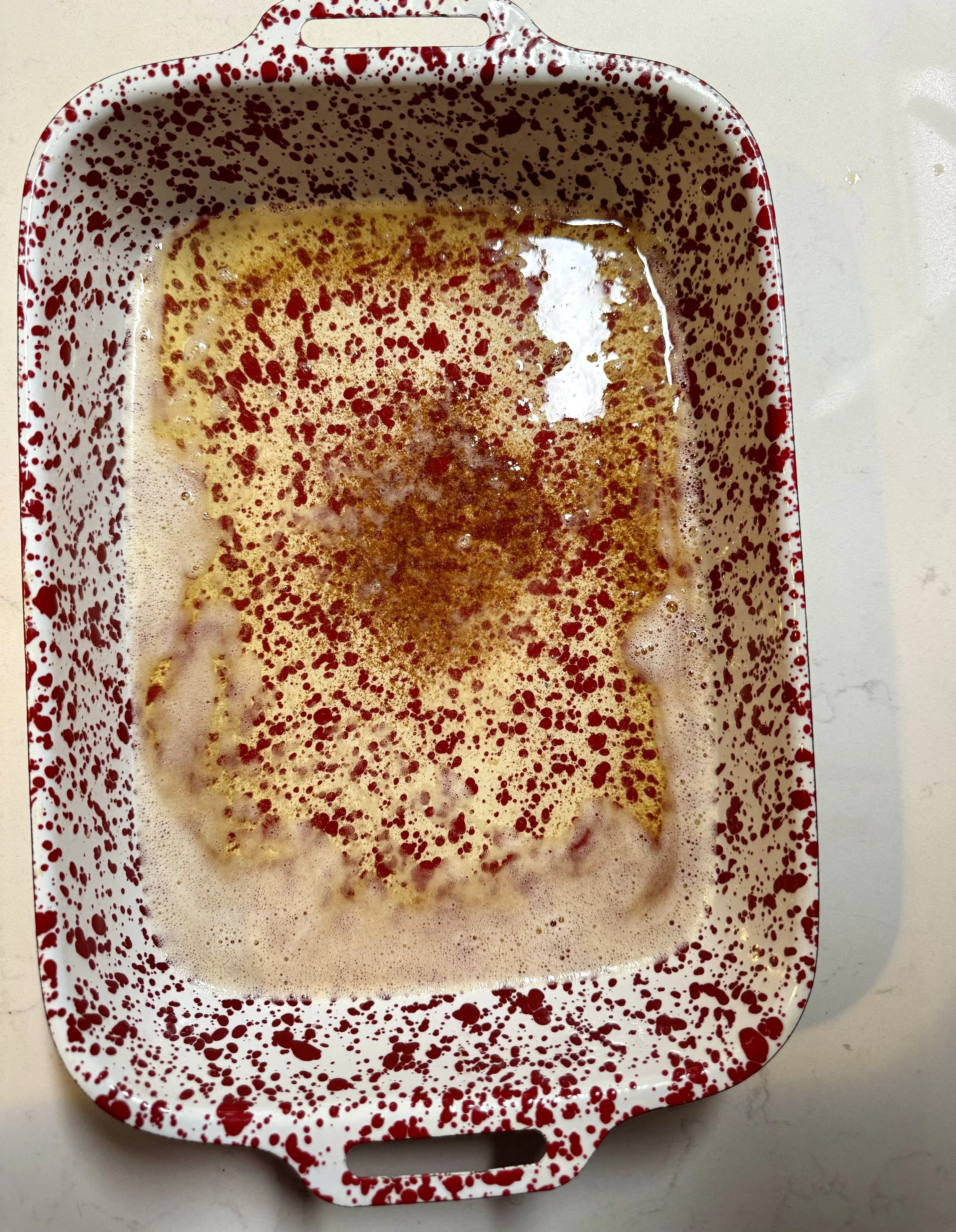 browned butter with nutty flavor and aroma poured in bottom of 9 x 13 cake pan ready for batter to be poured on top for chocolate cobbler.