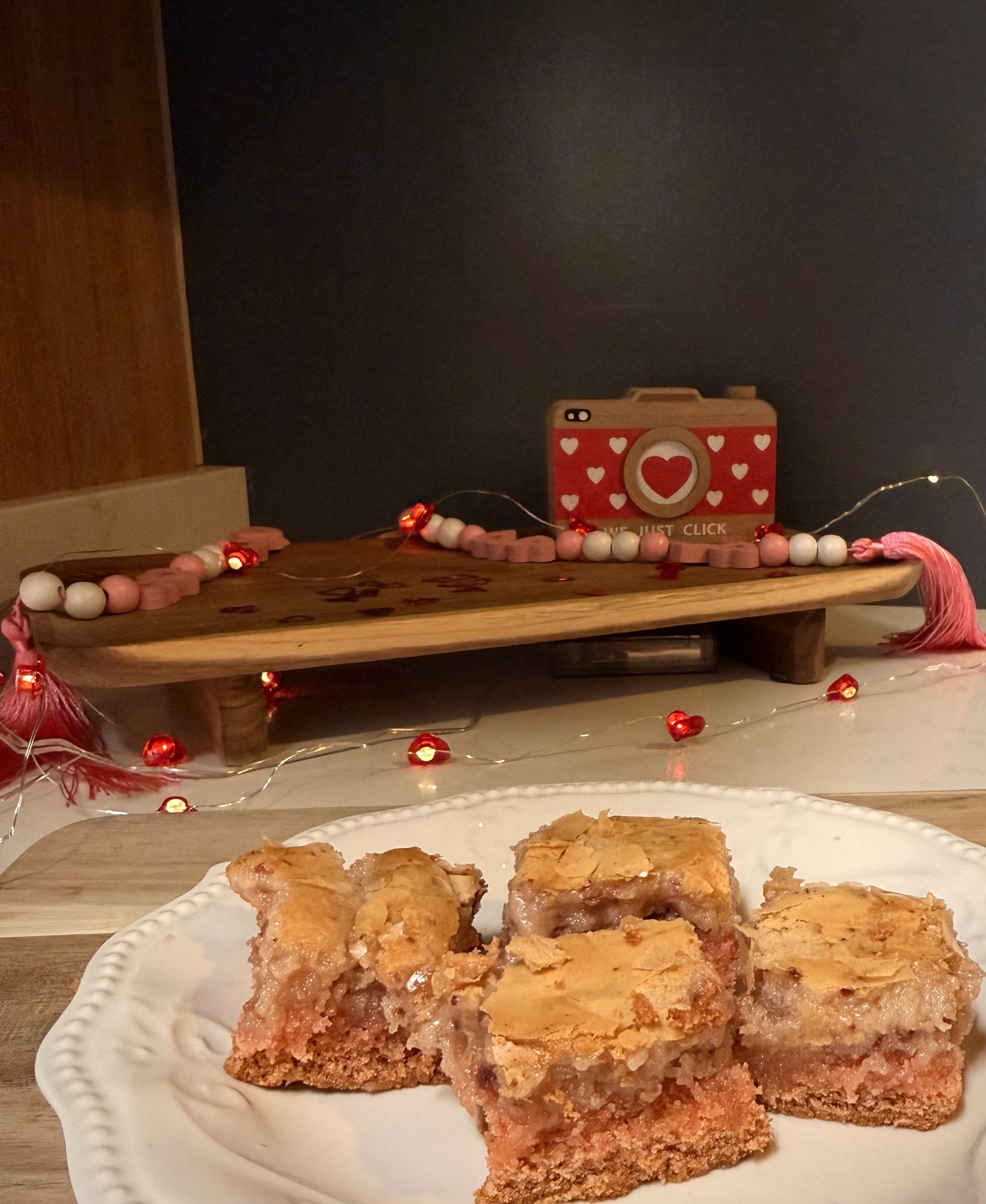 Gooey butter cake strawberry cake bars cut into individual squares ready for a Valentine's Day party.