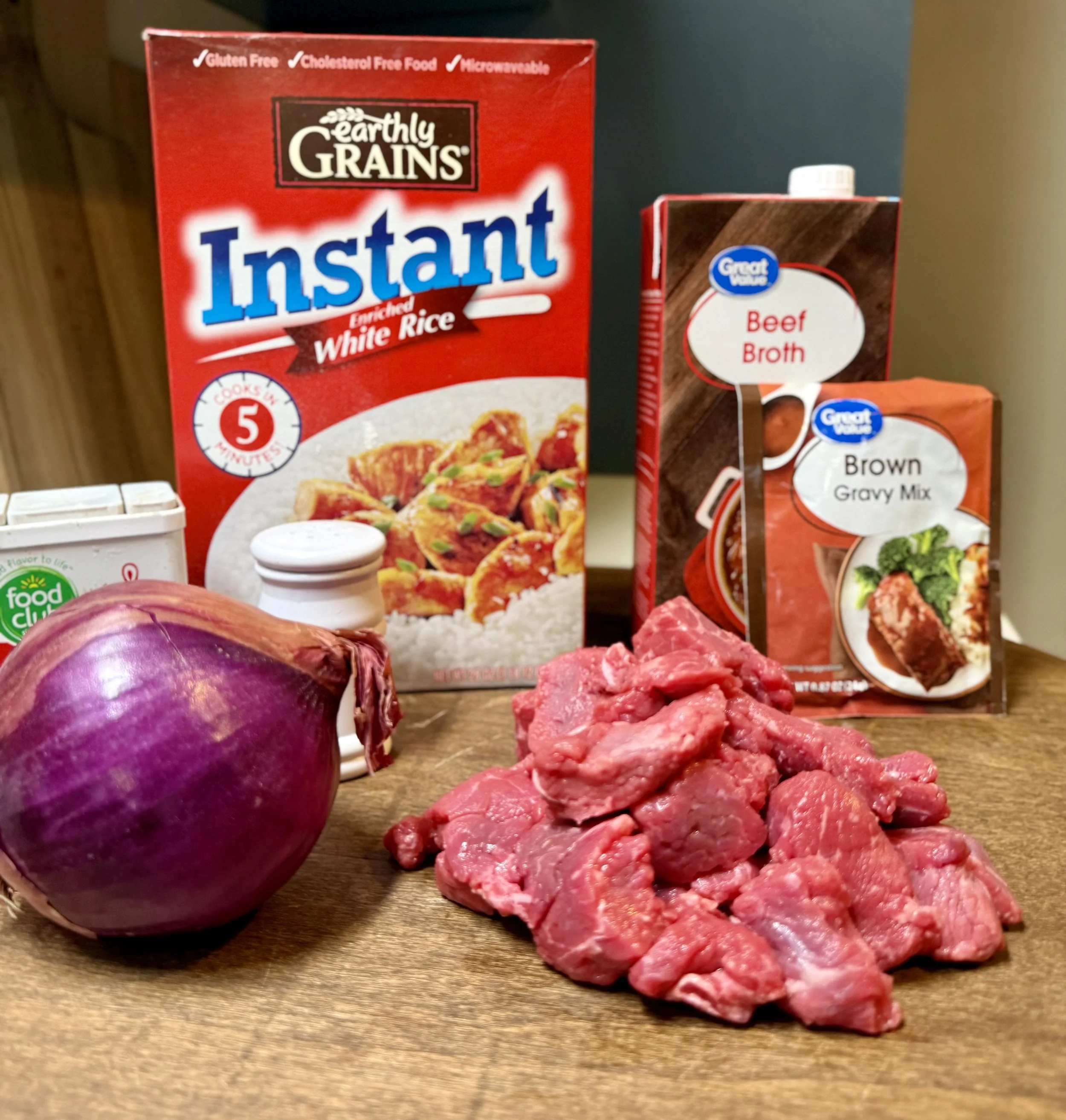 Close up picture of ingredients for beef tips and rice over gravy, the perfect budget friendly recipe for busy weeknight dinners.