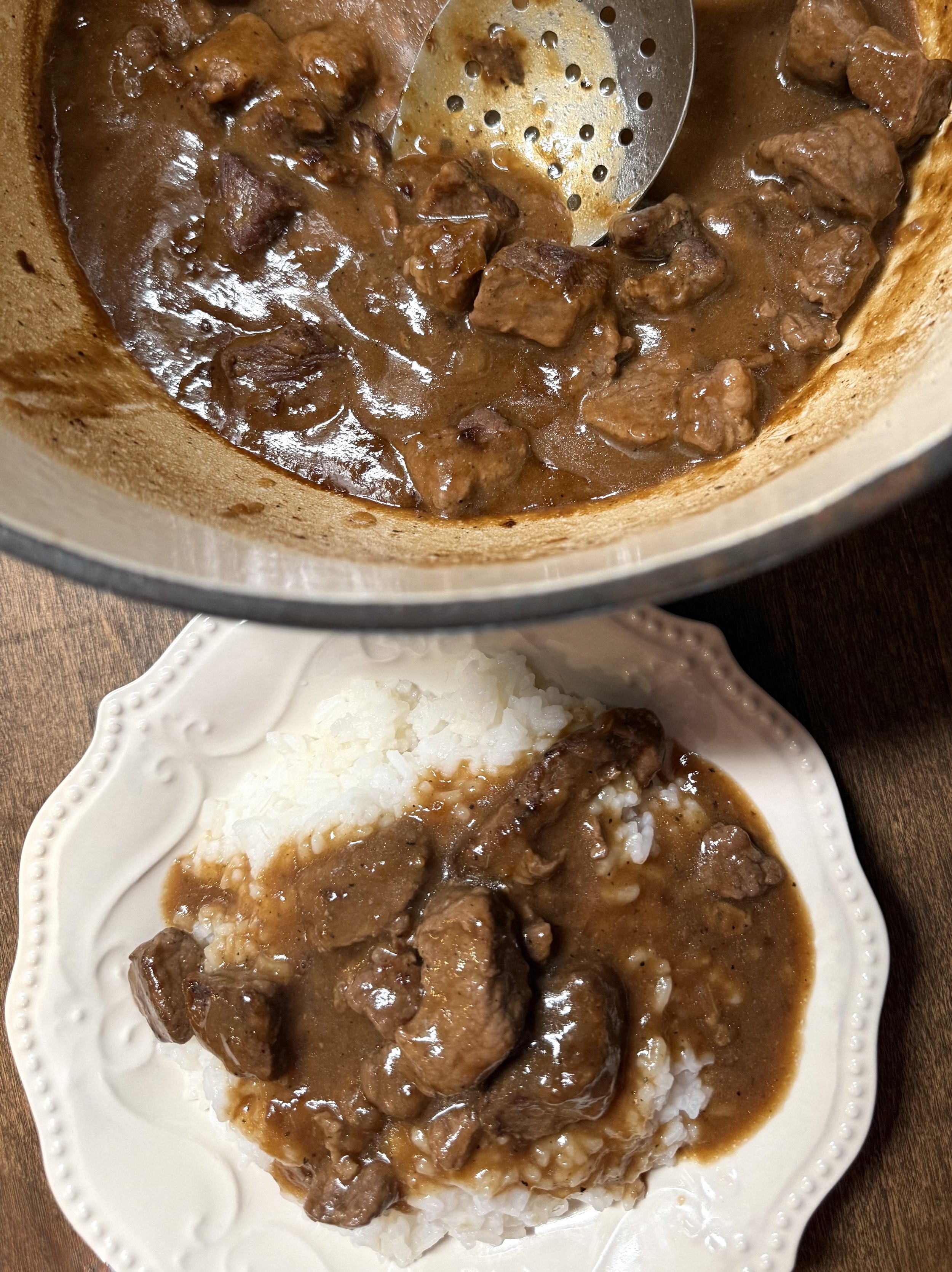 Overhead shot of beef tips and gravy in a Dutch oven served over rice, it's the most cozy and amazing use of beef stew meat.