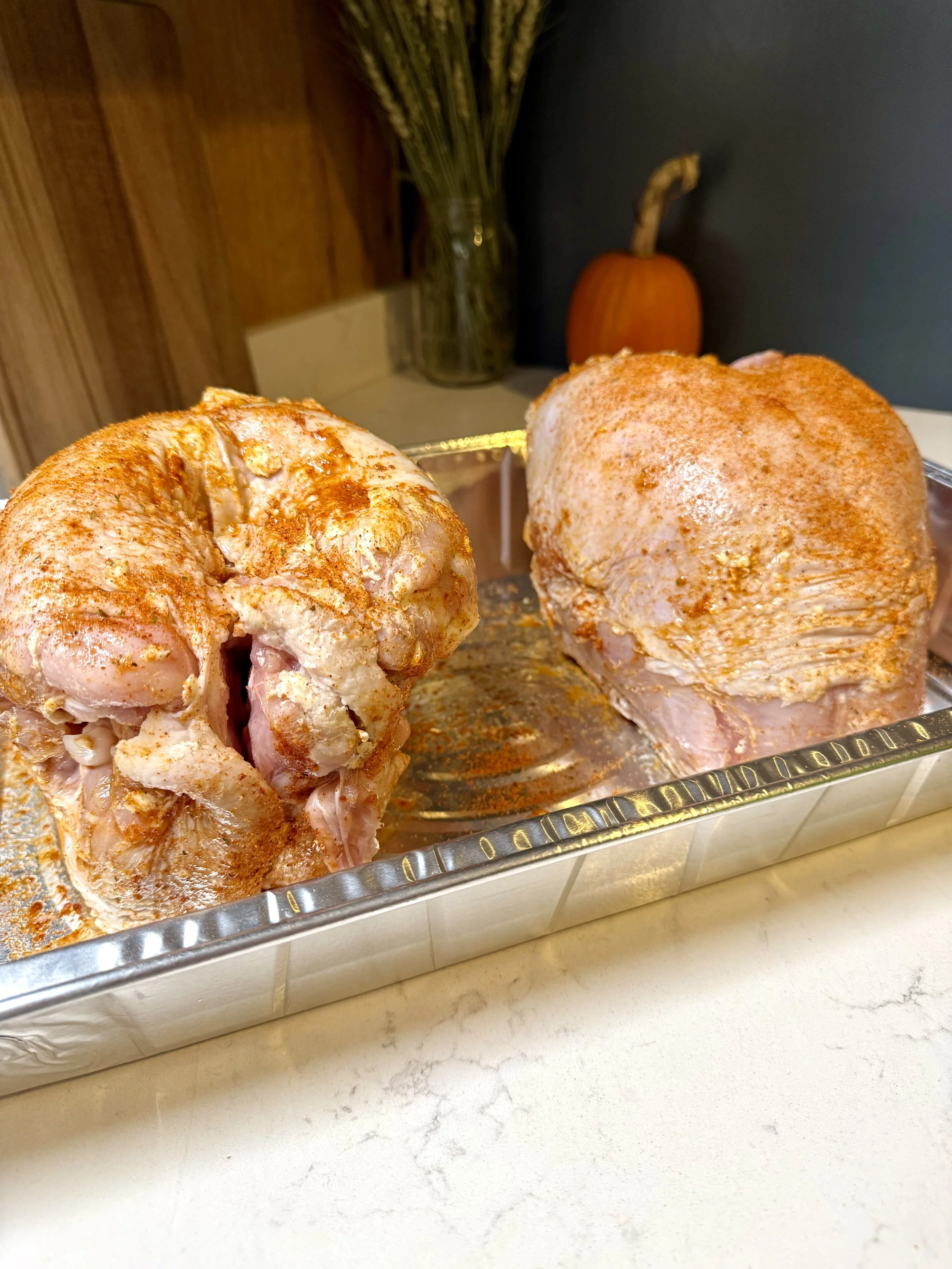 Two bone-in turkey breasts injected with marinade and ready for the smoker.
