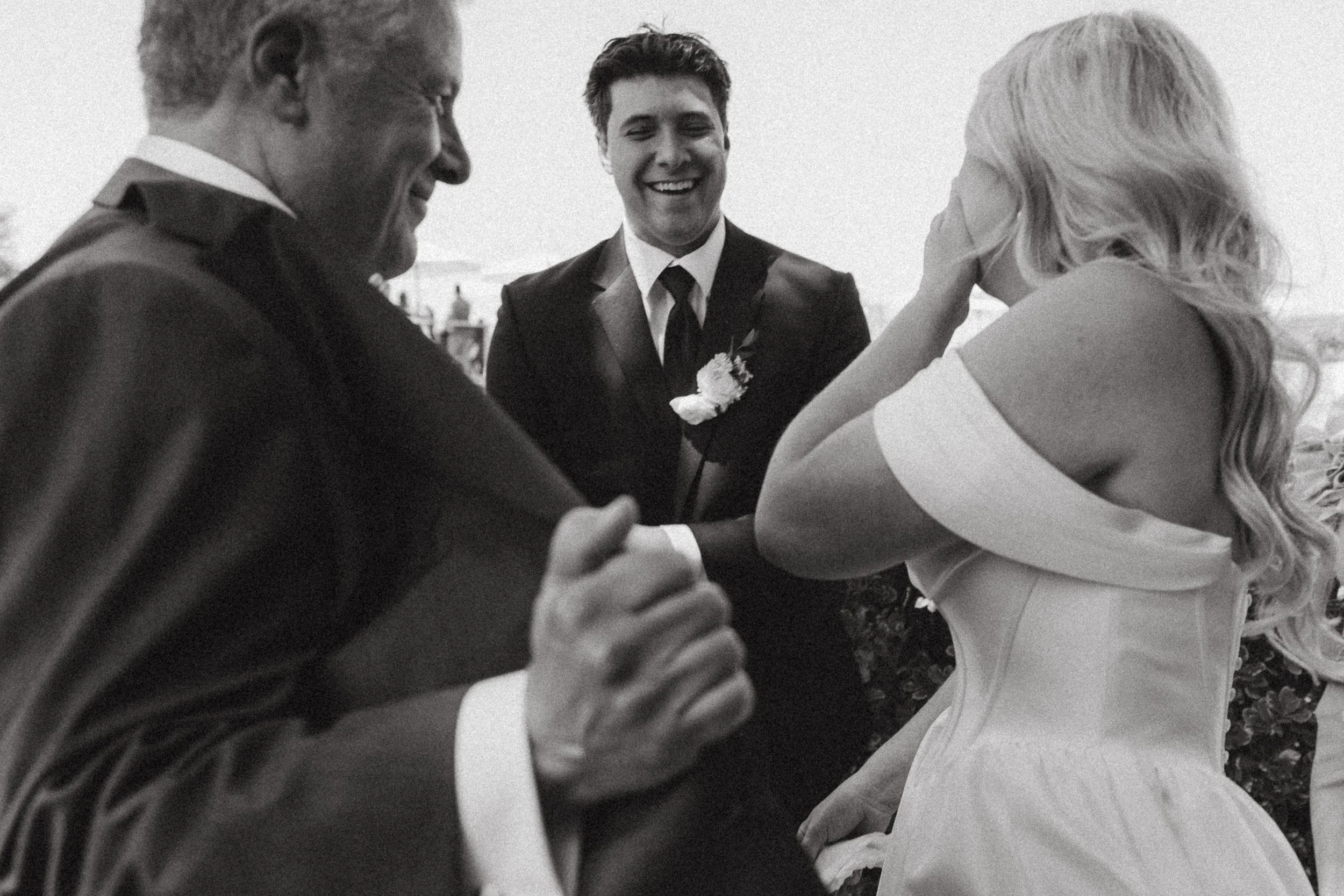 Bride wipes away a tear during an emotional first look in black and white