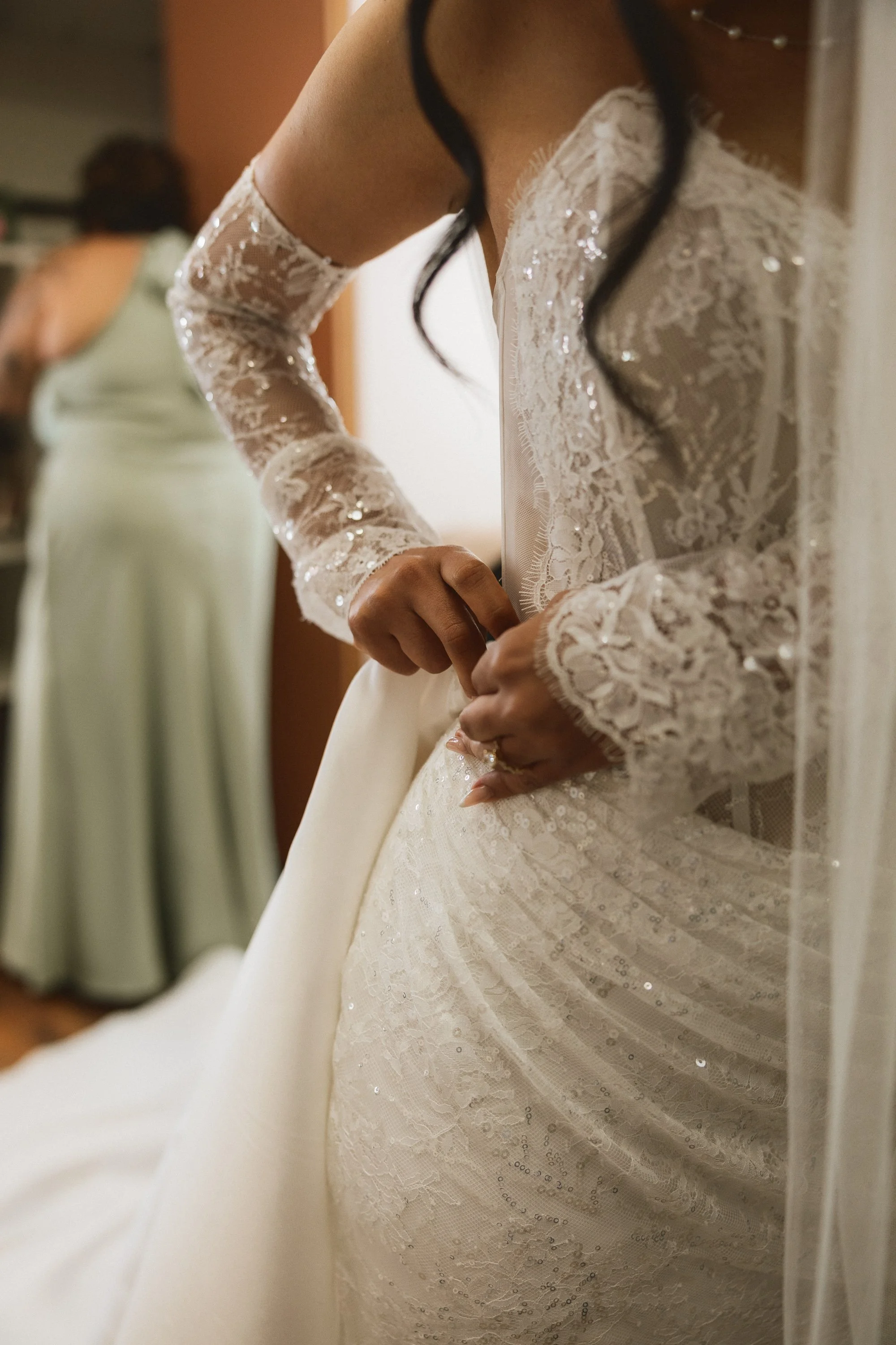 Close-up of lace and sequin detail on bride’s wedding dress