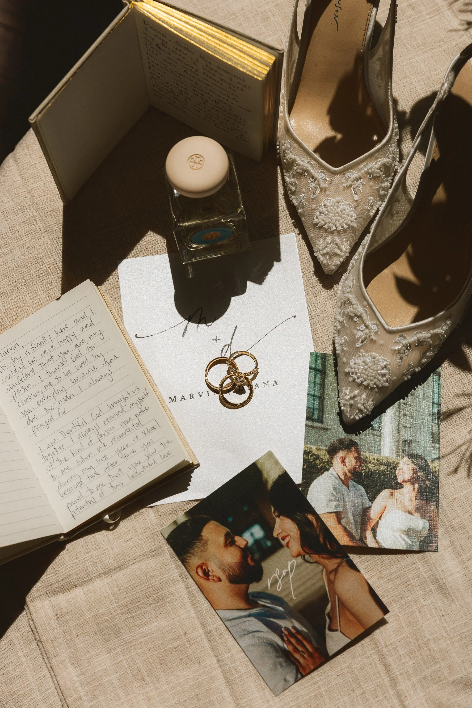 Flat lay of wedding shoes, rings, vows, and invitations at Los Angeles River Center wedding