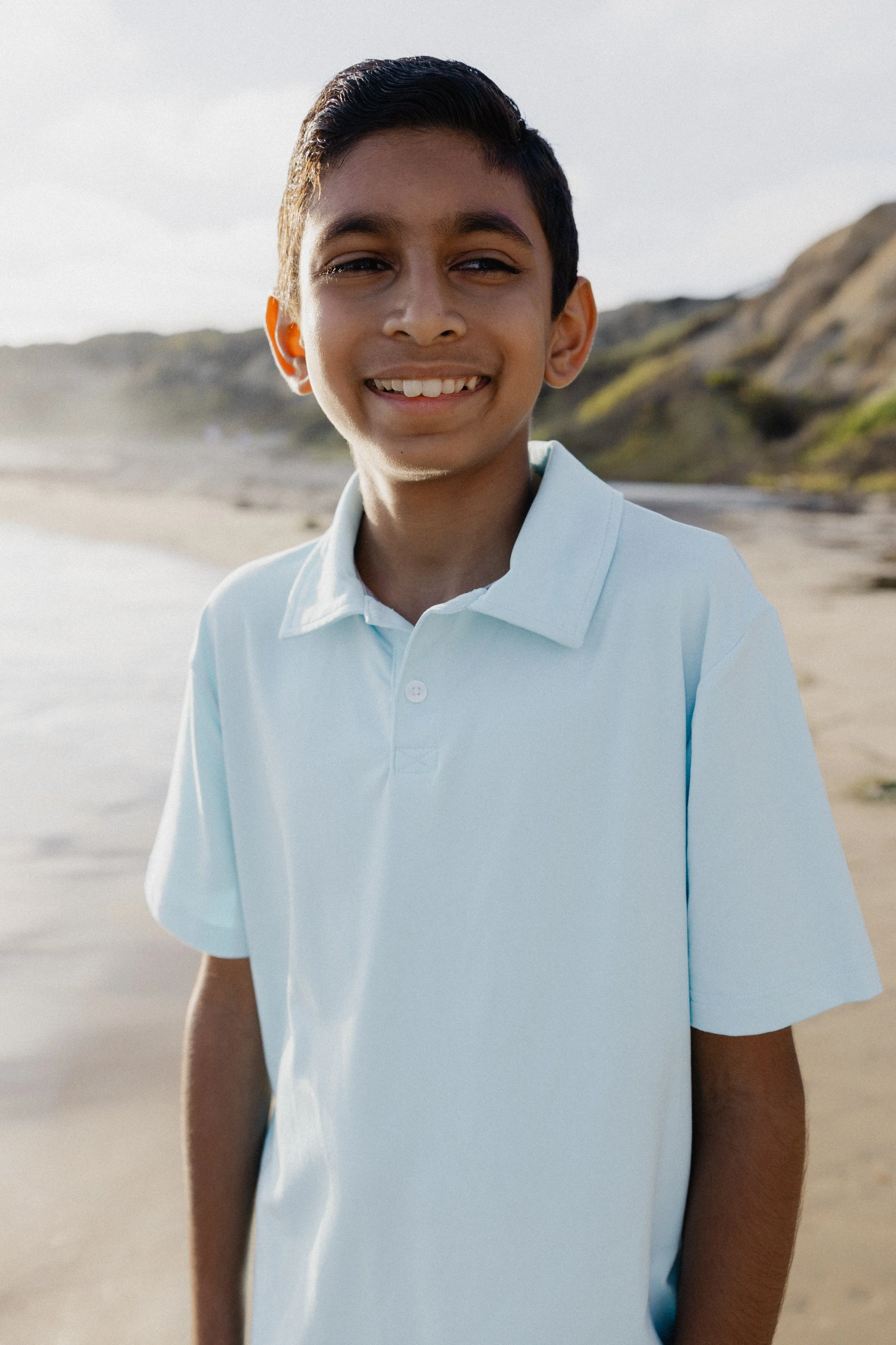 Portrait of youngest son smiling during a Newport Beach family photo session at Crystal Cove.
