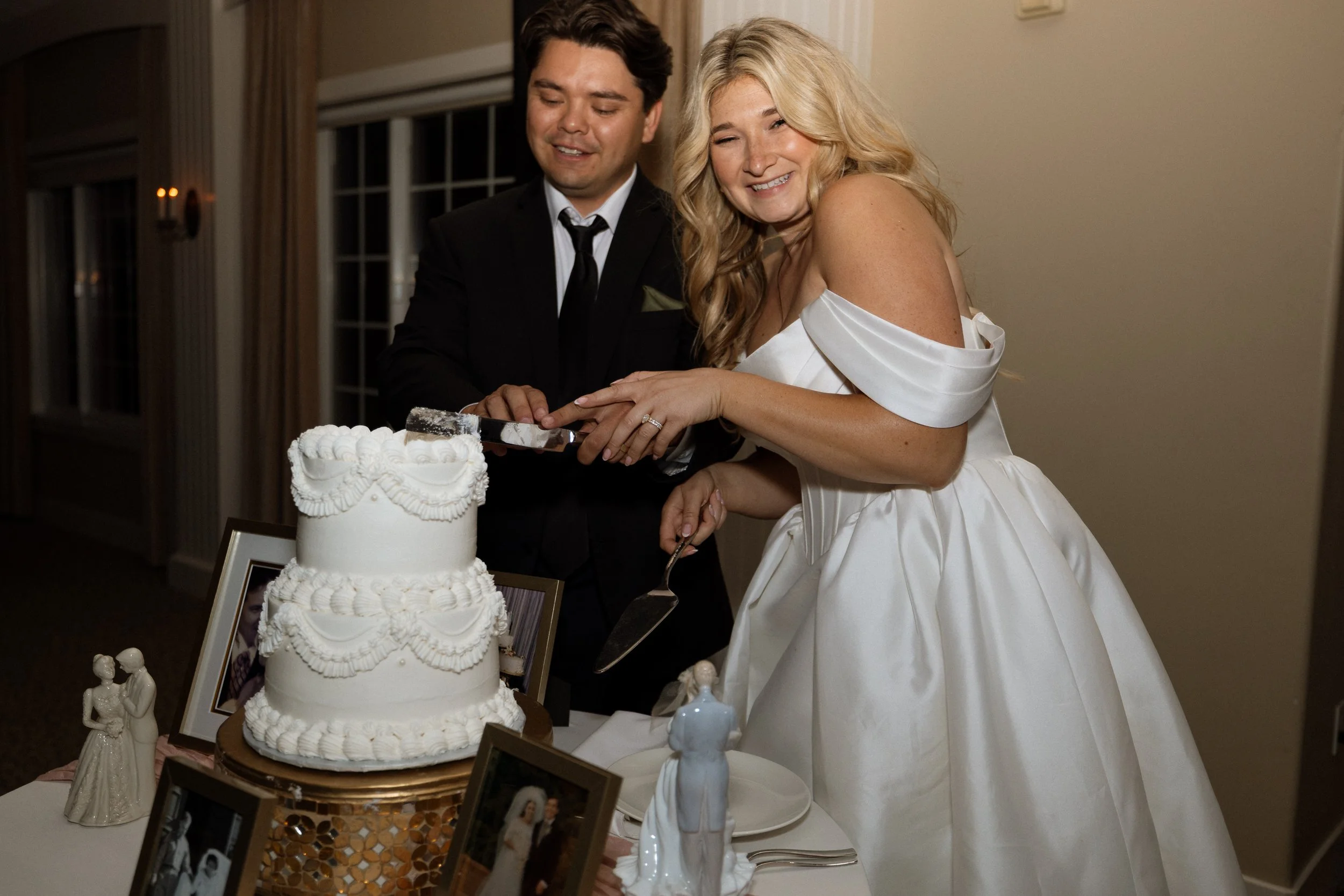 Bride and groom cut their tiered wedding cake together