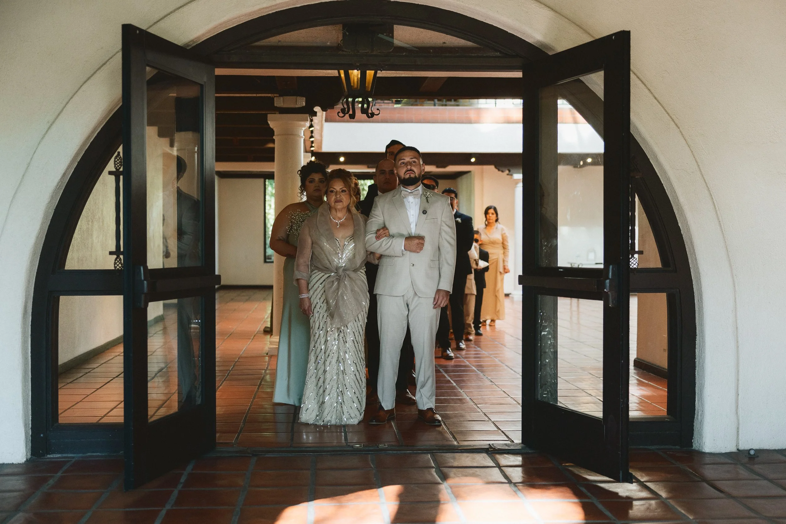Groom walking into ceremony with family at Los Angeles River Center
