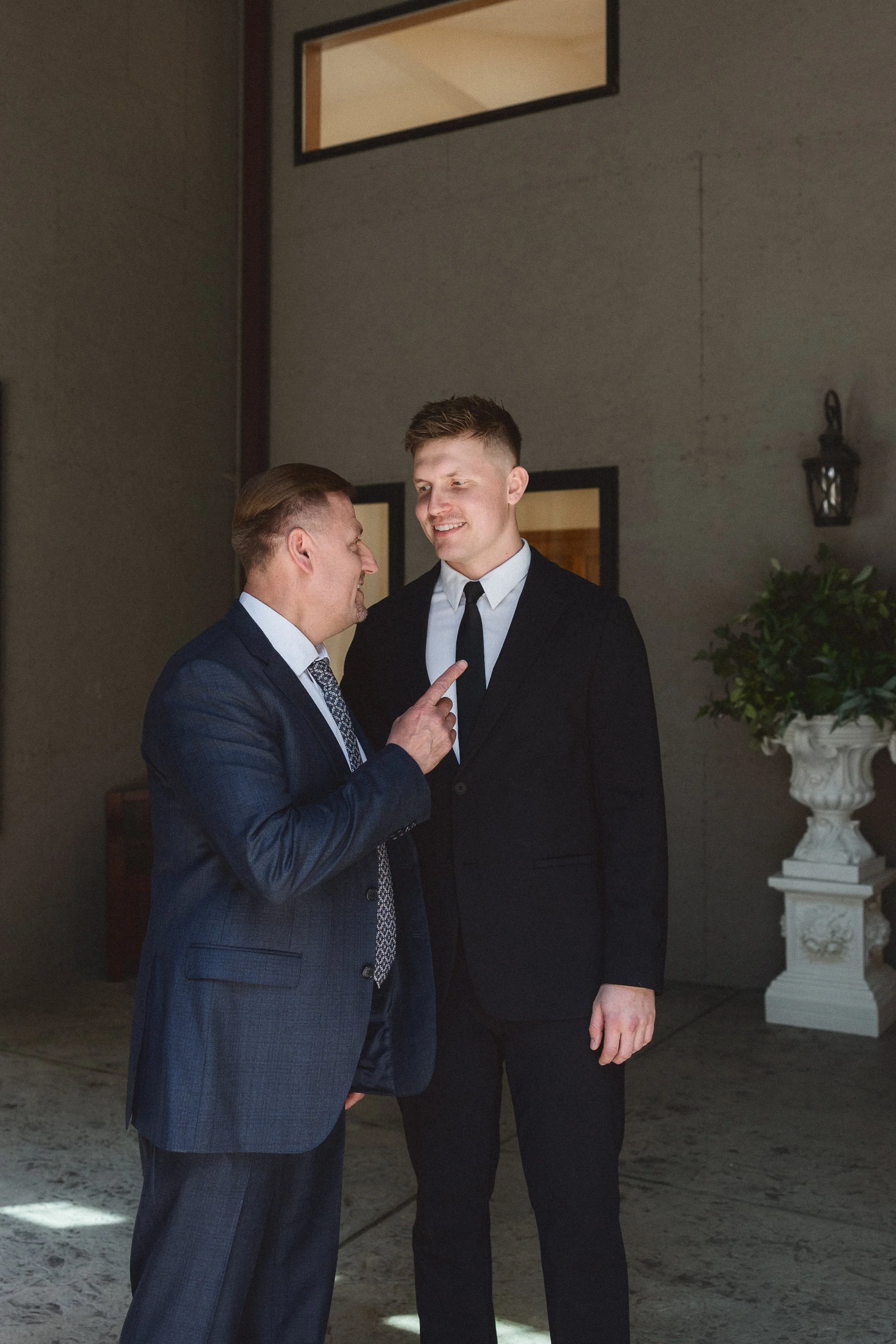 Groom having a quiet conversation with a father figure before the ceremony.