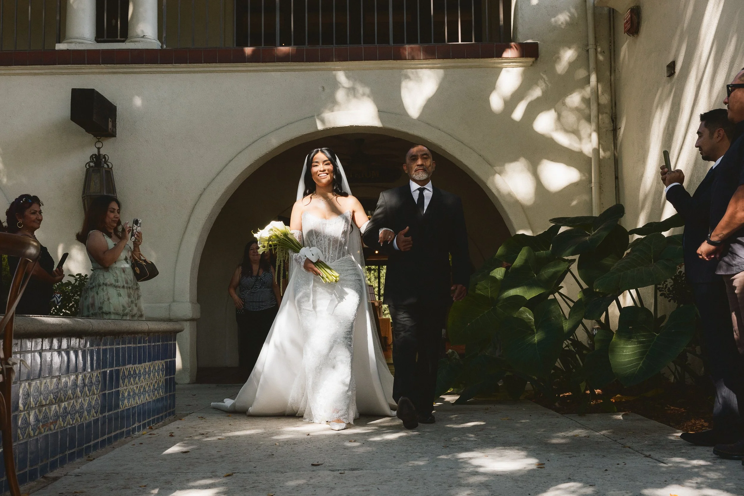 Bride entering the courtyard ceremony with her father at Los Angeles River Center