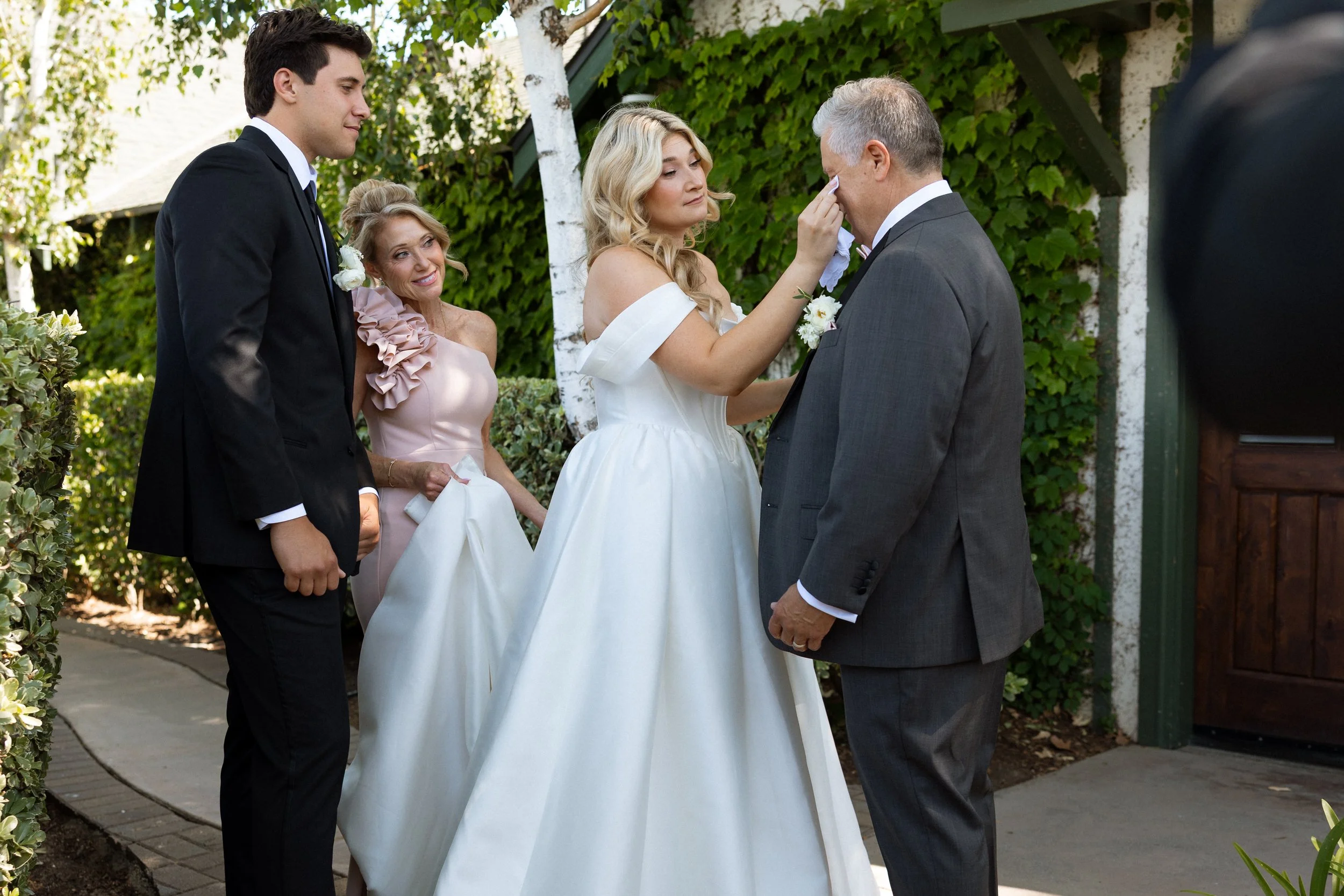 Bride gently wipes away her father's tears during their first look