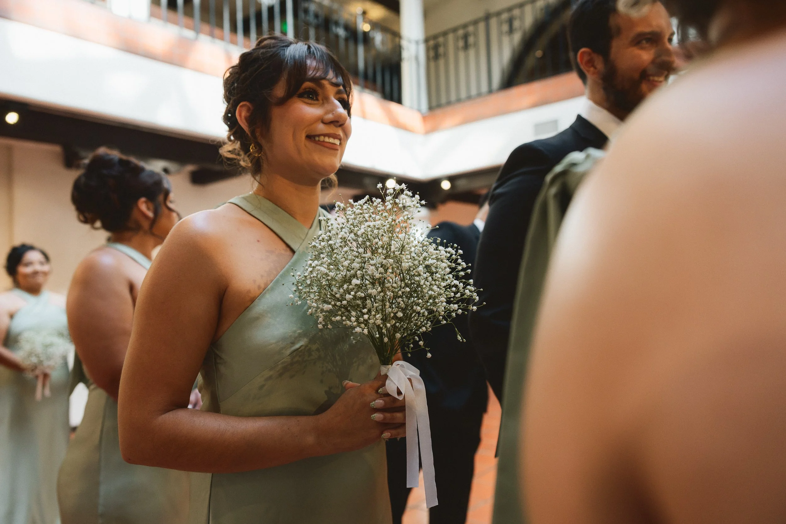 Bridesmaid holding baby’s breath bouquet before ceremony