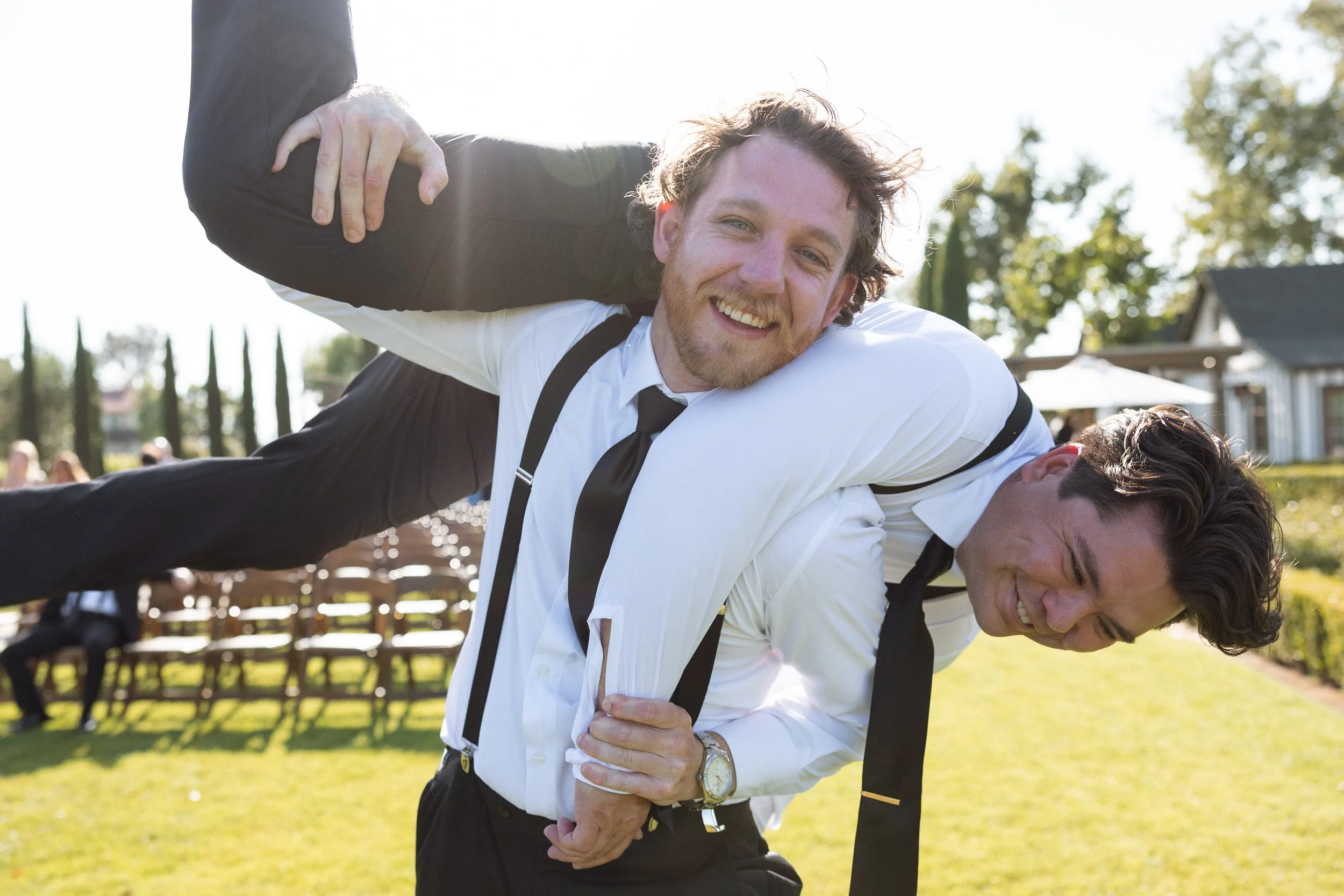 Groomsman hoists another over his shoulder in a playful moment