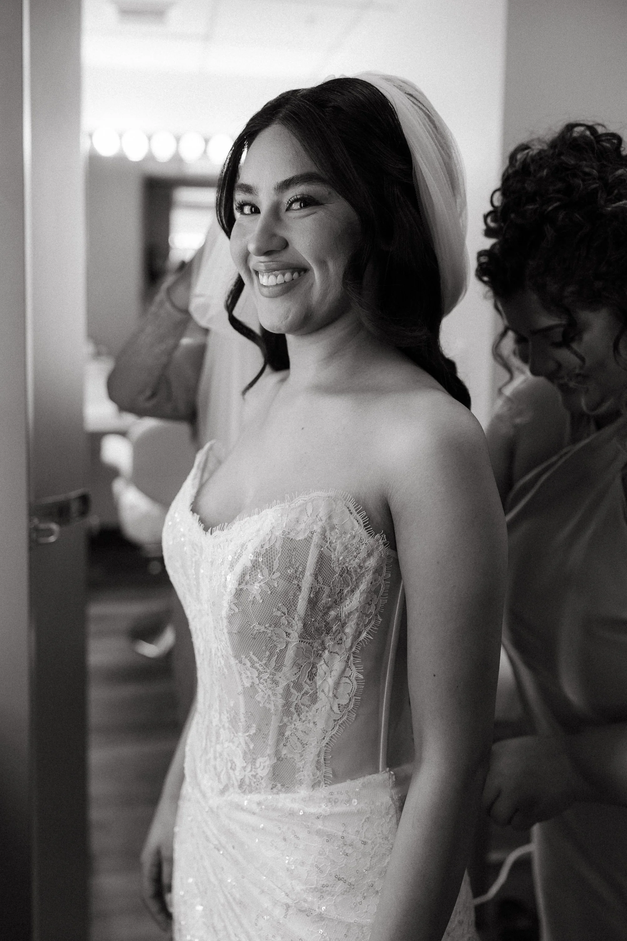Bride smiling while getting ready before ceremony at Los Angeles River Center