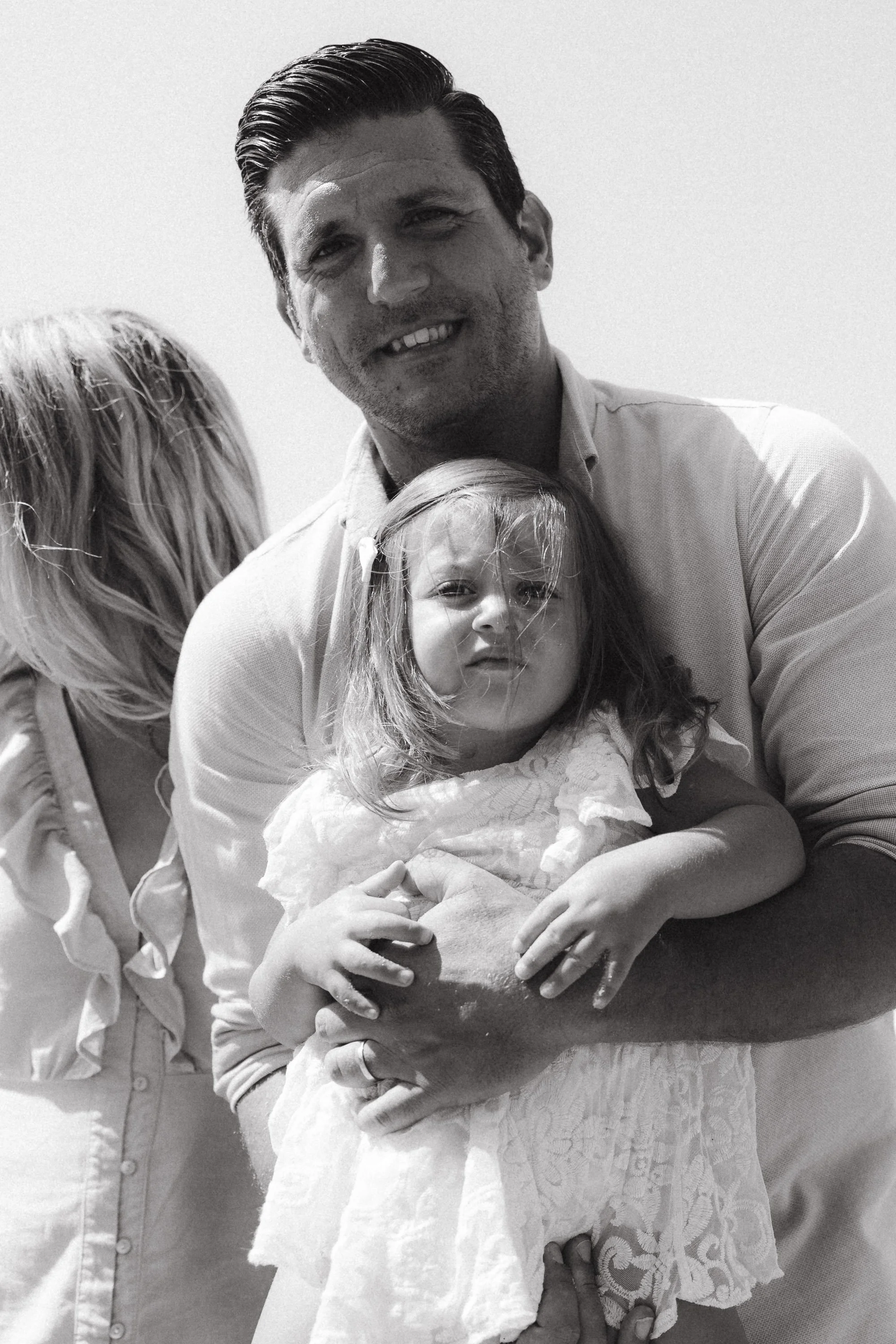 Father lifting his toddler daughter in the air, creating a heartwarming portrait.