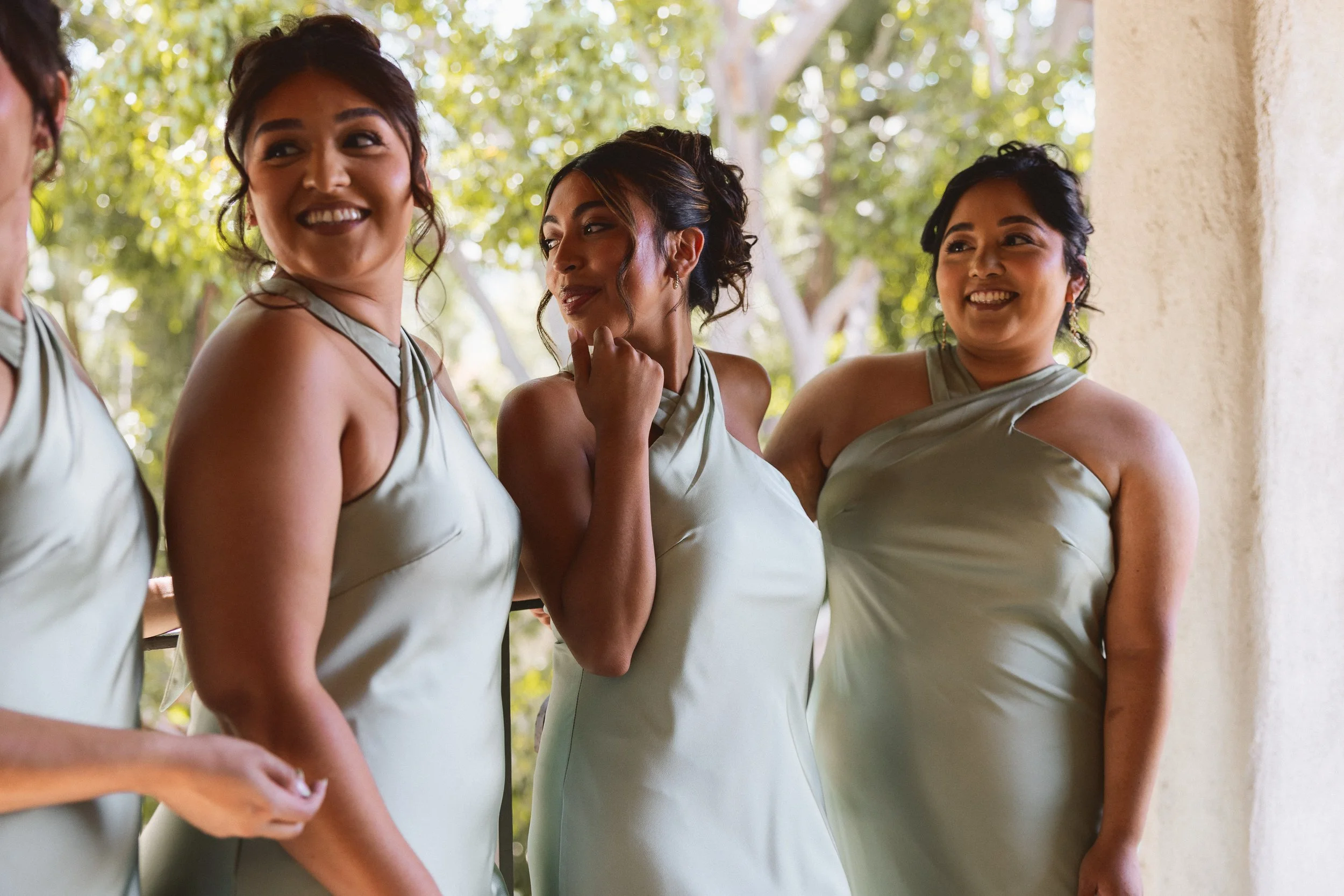 Bridesmaids sharing a candid moment during portraits at Los Angeles River Center