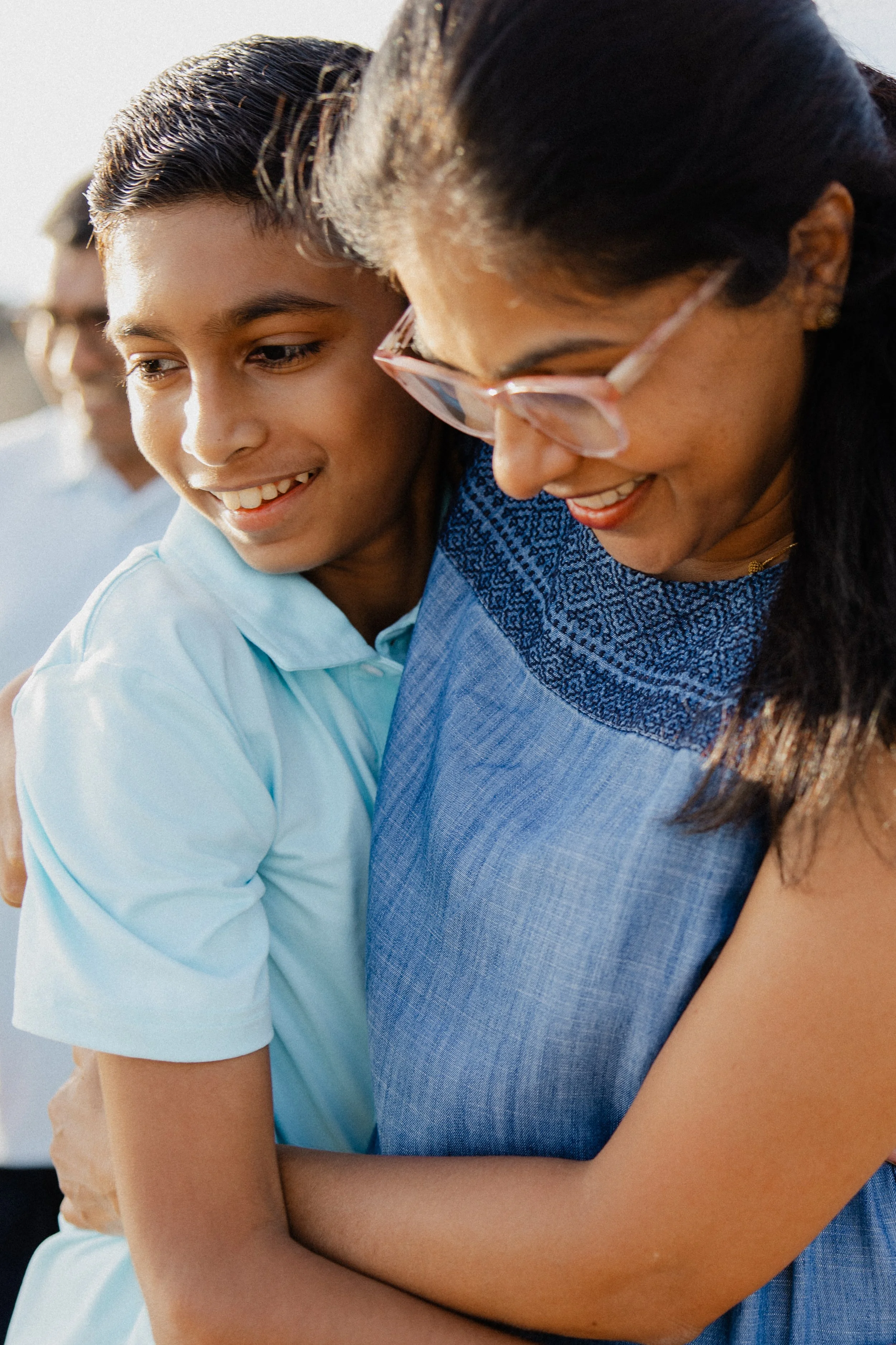 Close-up of mother hugging her son during a candid family photo session at Crystal Cove beach.