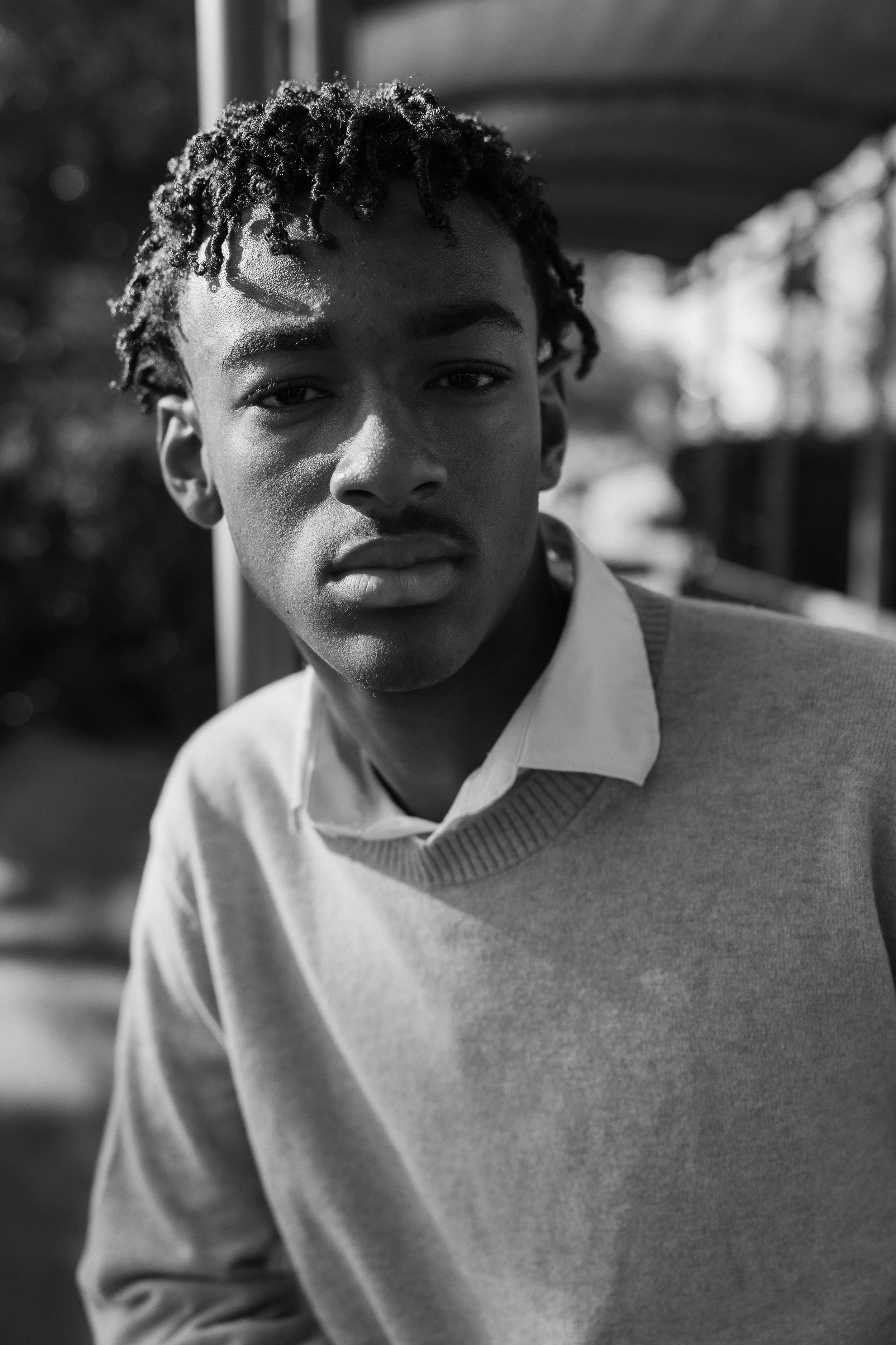 Black and white close-up portrait of a teenage boy looking serious and stylish during a family session in Irvine.