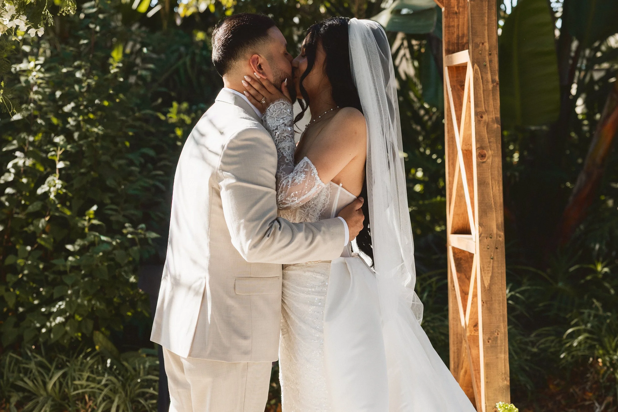Bride and groom sharing first kiss at Los Angeles River Center and Gardens wedding ceremony.