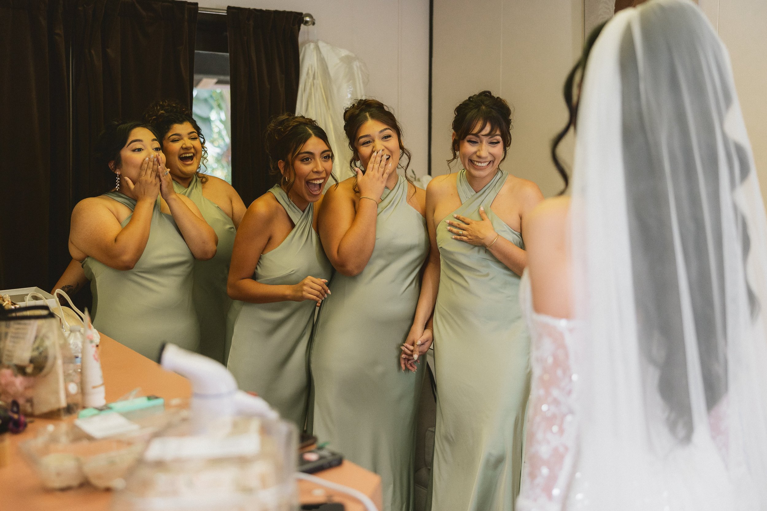 Bridesmaids reacting with joy during bride’s first look reveal