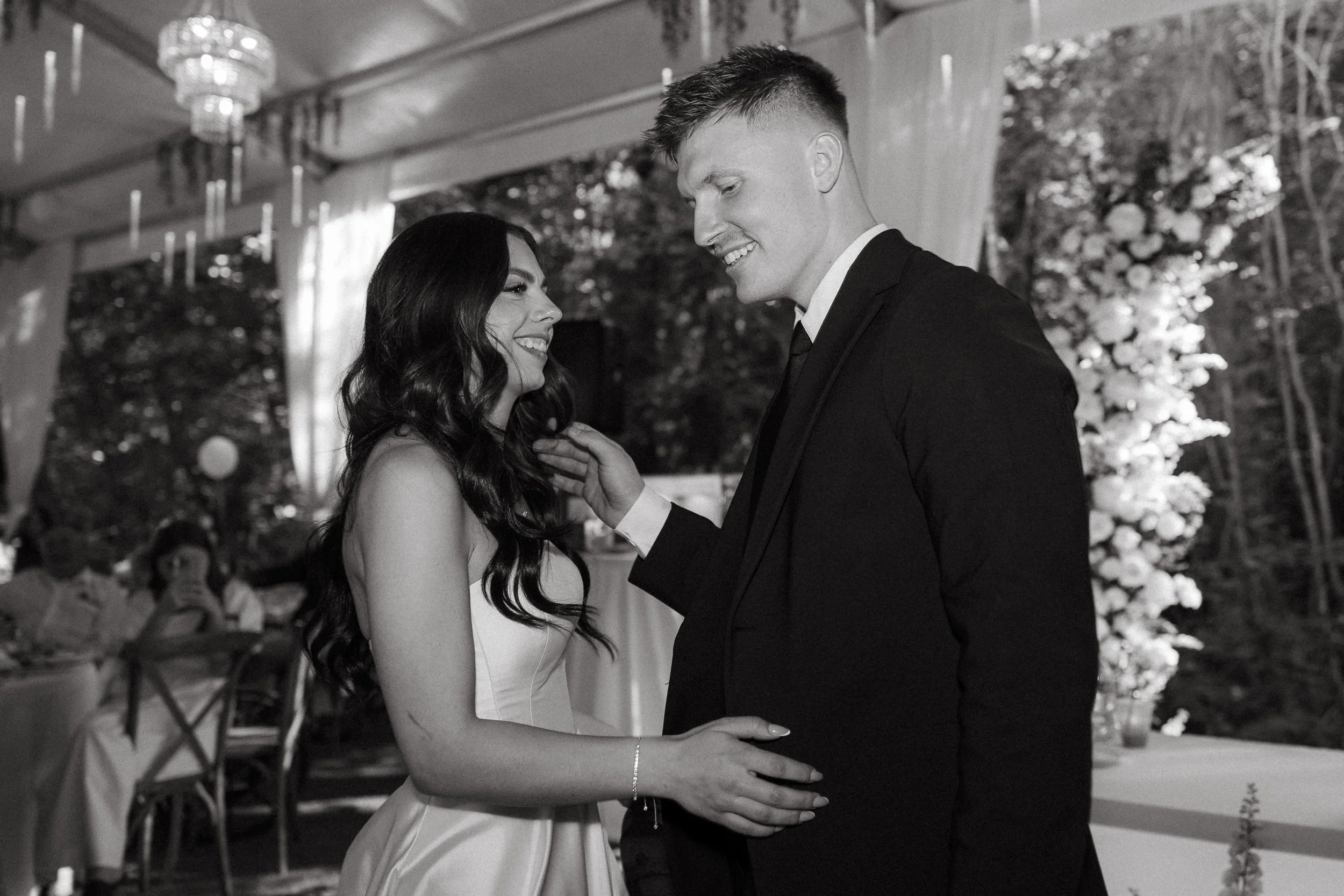 Bride and groom share a laugh during their first dance inside reception tent