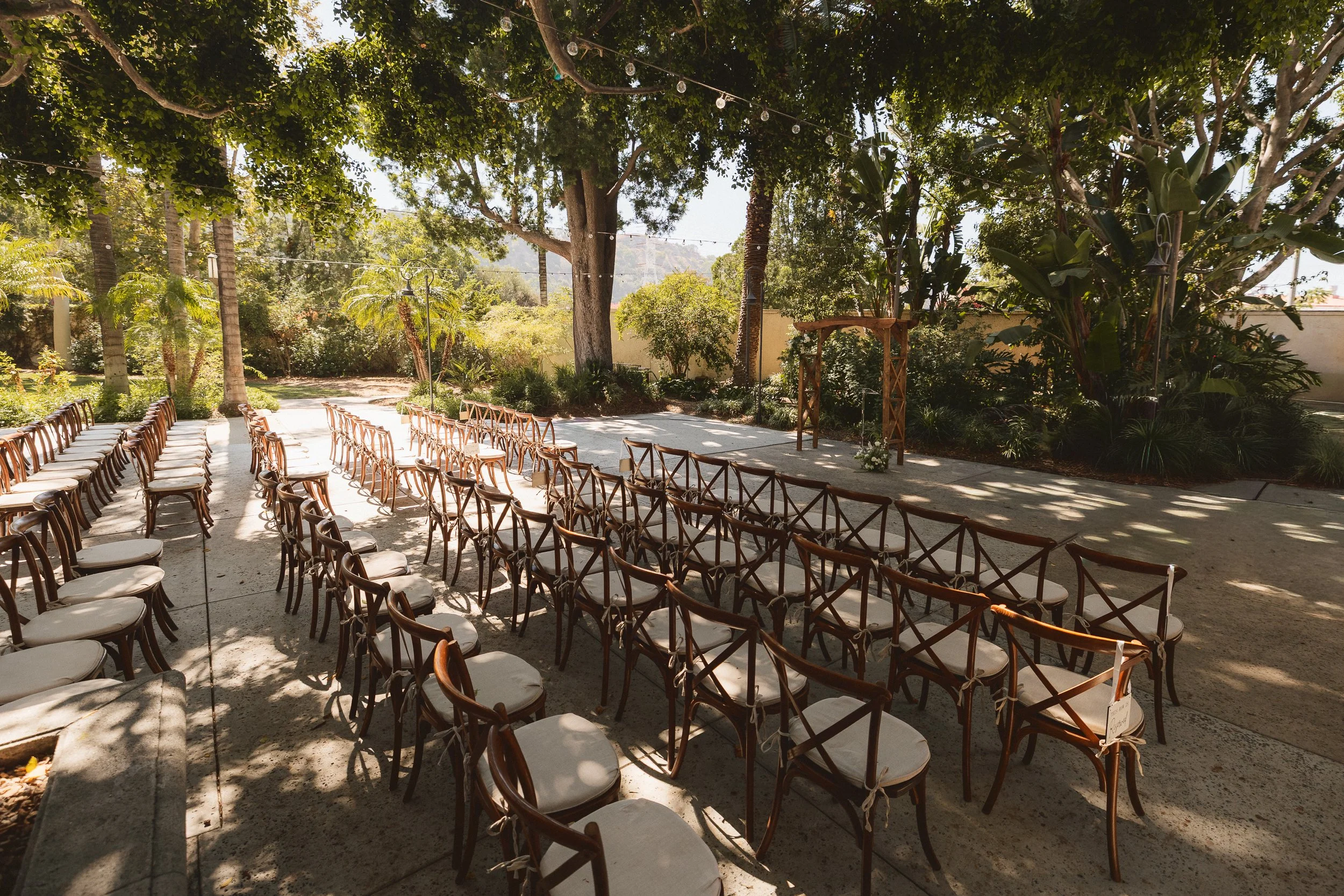 Outdoor wedding ceremony setup with wooden chairs and arch at Los Angeles River Center