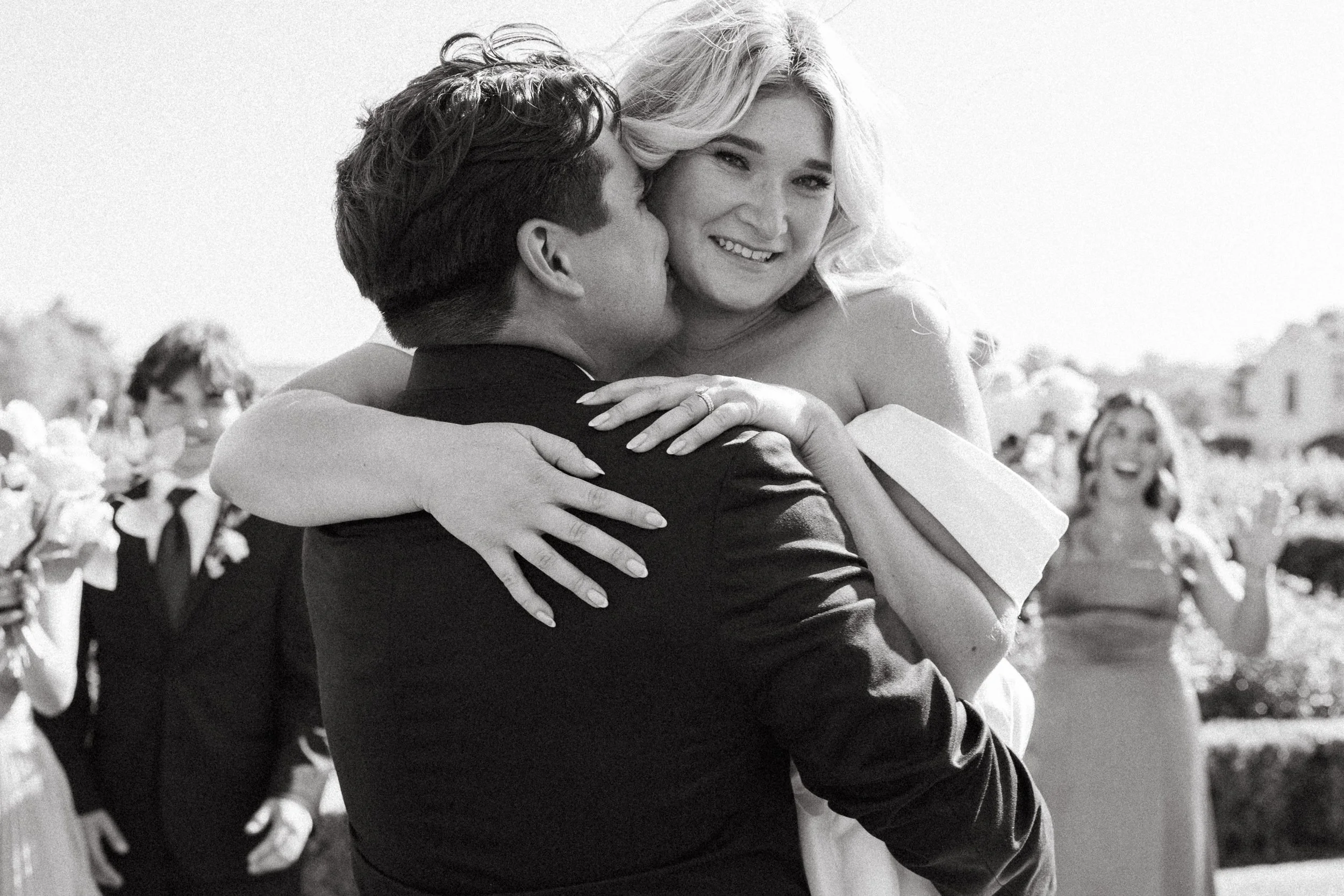 Bride and groom embrace as guests cheer after their Ponte Winery ceremony