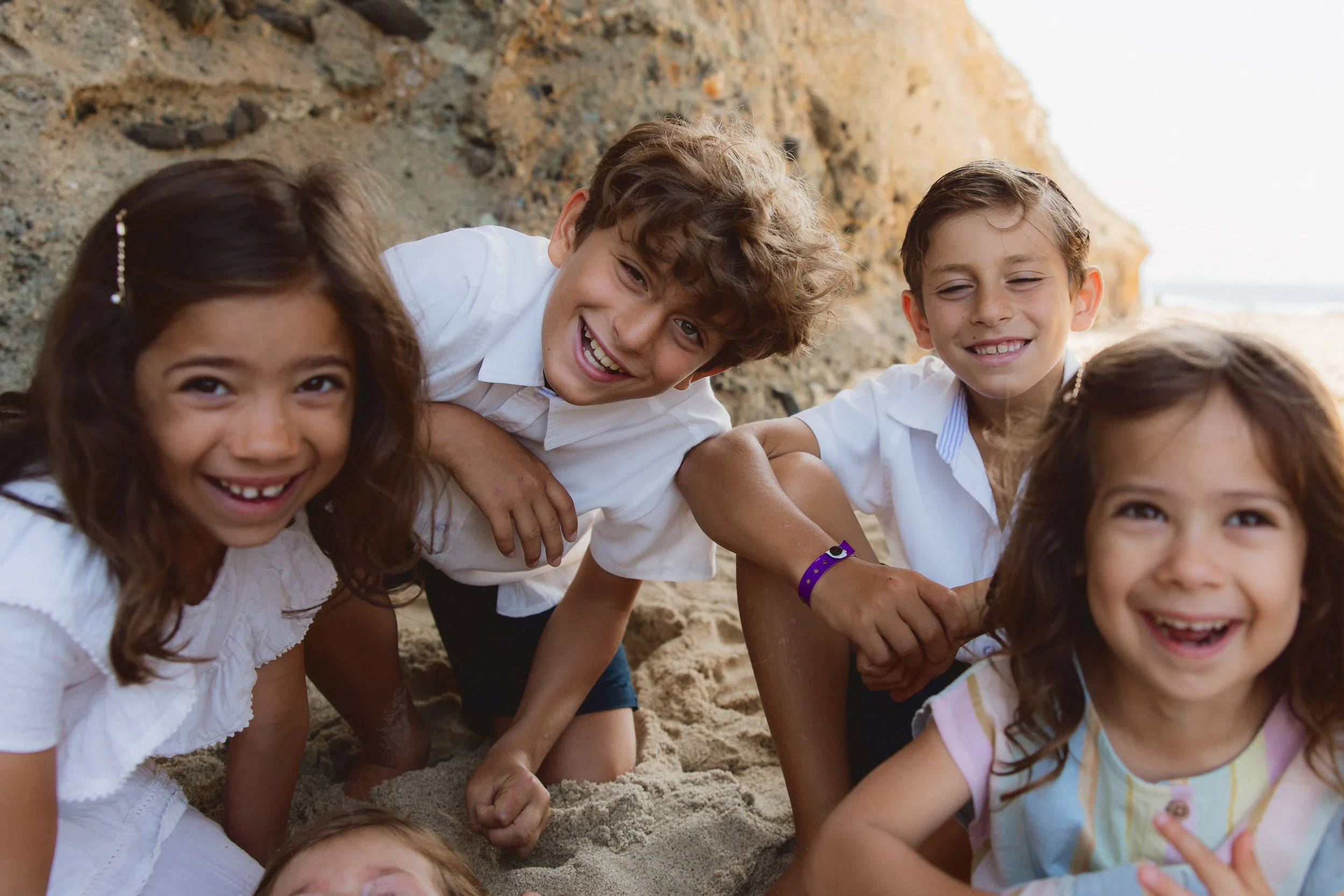 Joyful children laughing together during a family photoshoot in Laguna Beach, California.