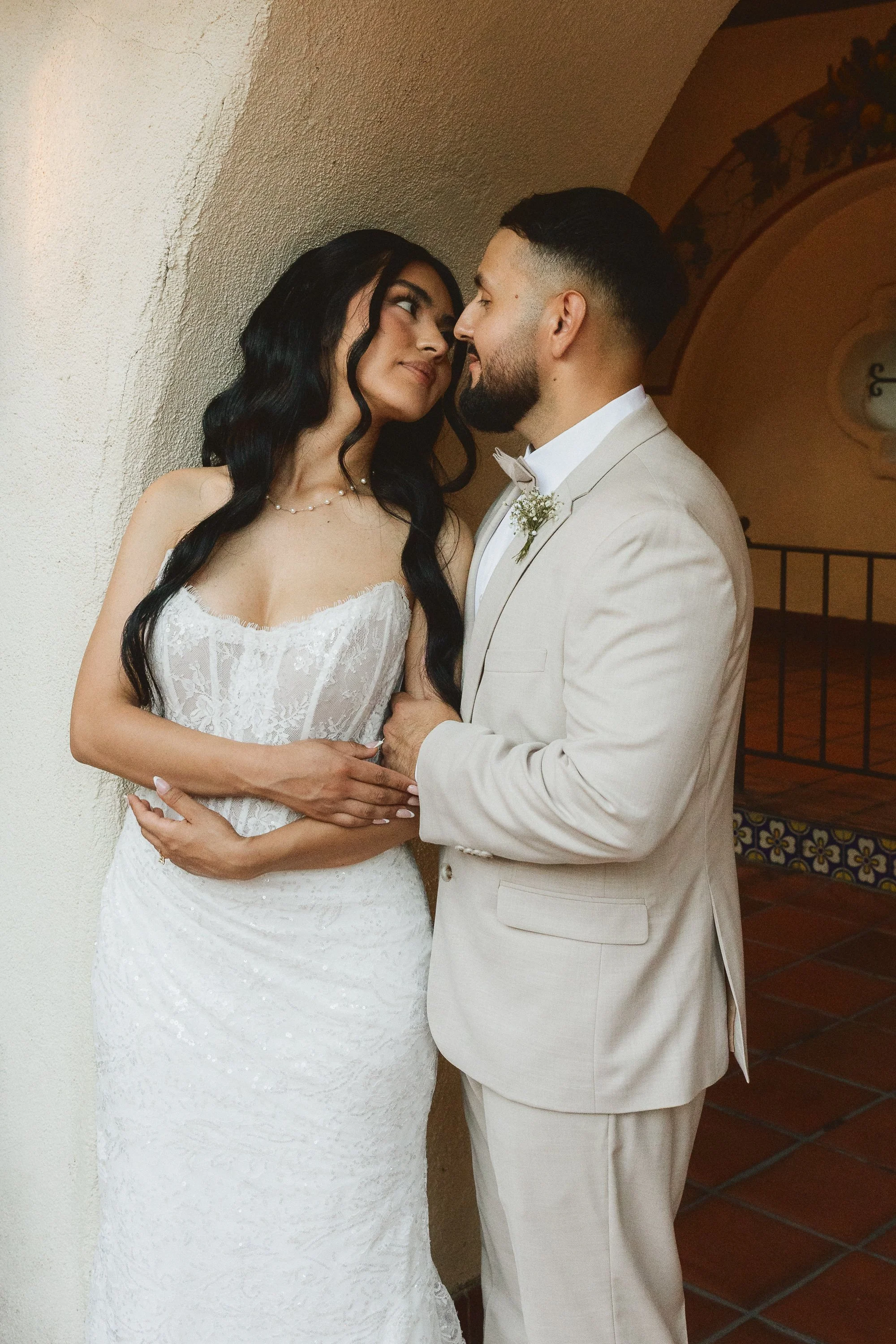 Bride and groom sharing a quiet moment under Spanish-style archway at Los Angeles River Center