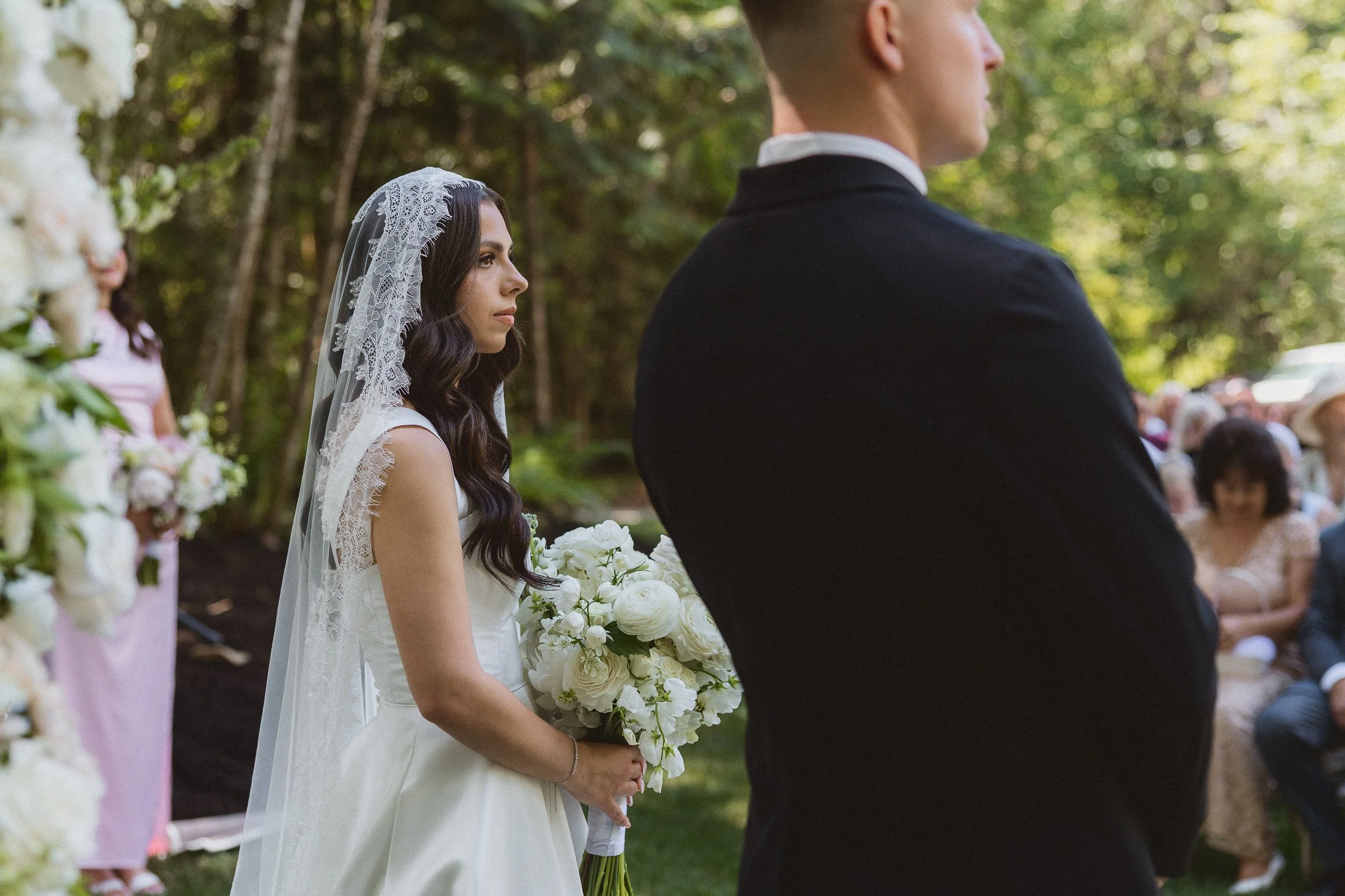 Bride holding her bouquet and listening during the wedding ceremony.