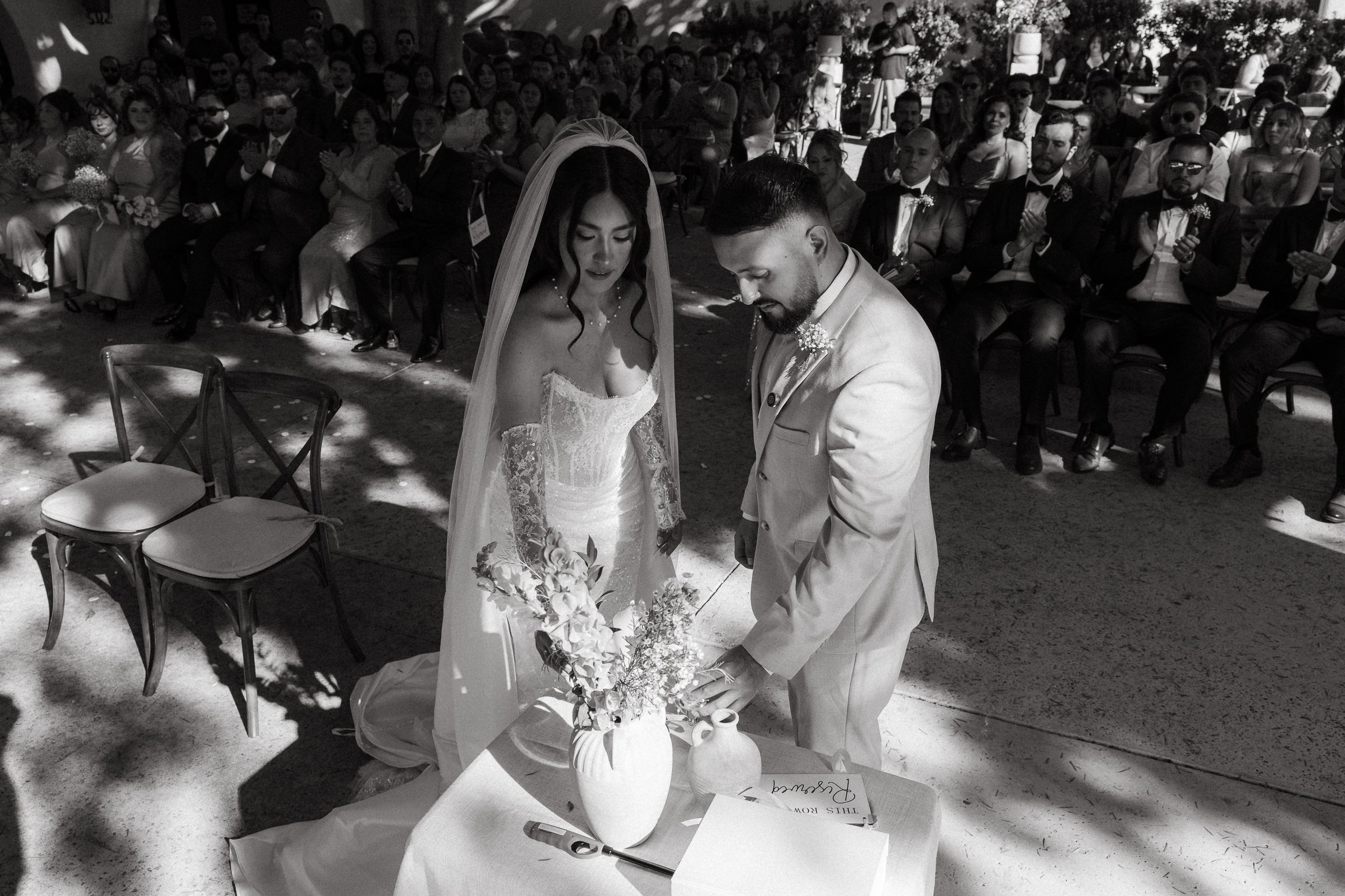 Bride and groom pouring unity sand during outdoor ceremony at Los Angeles River Center and Gardens.