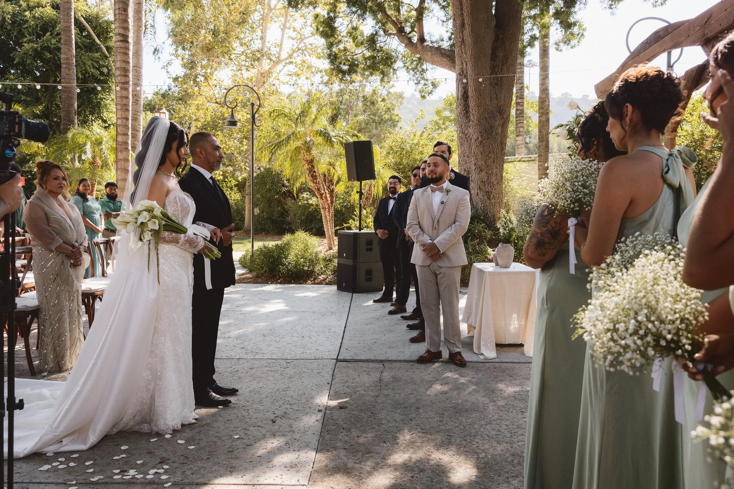 Groom smiling as he sees bride walking down the aisle