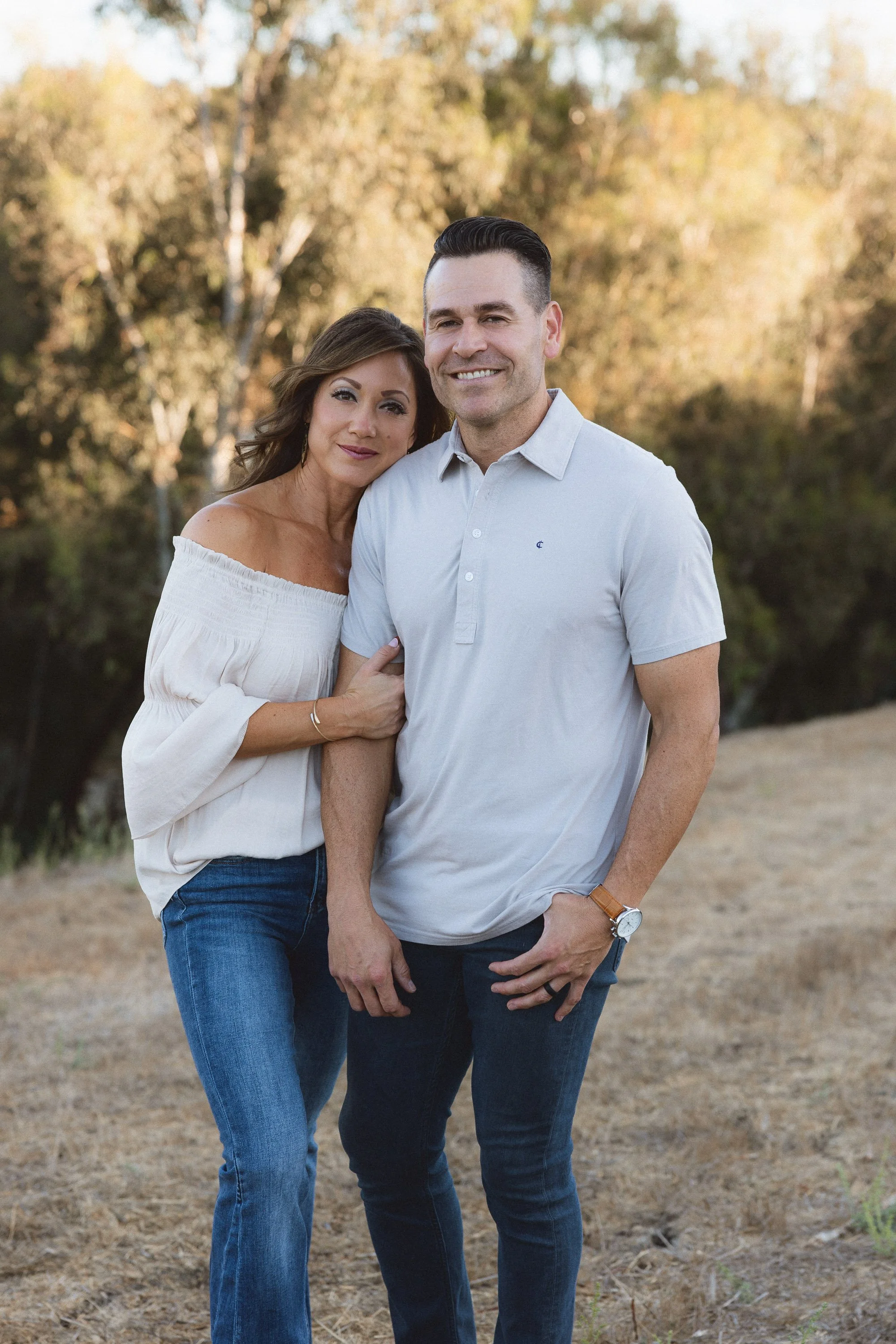 Jason and Natasha Pfeiffer standing close together posing for a portrait.