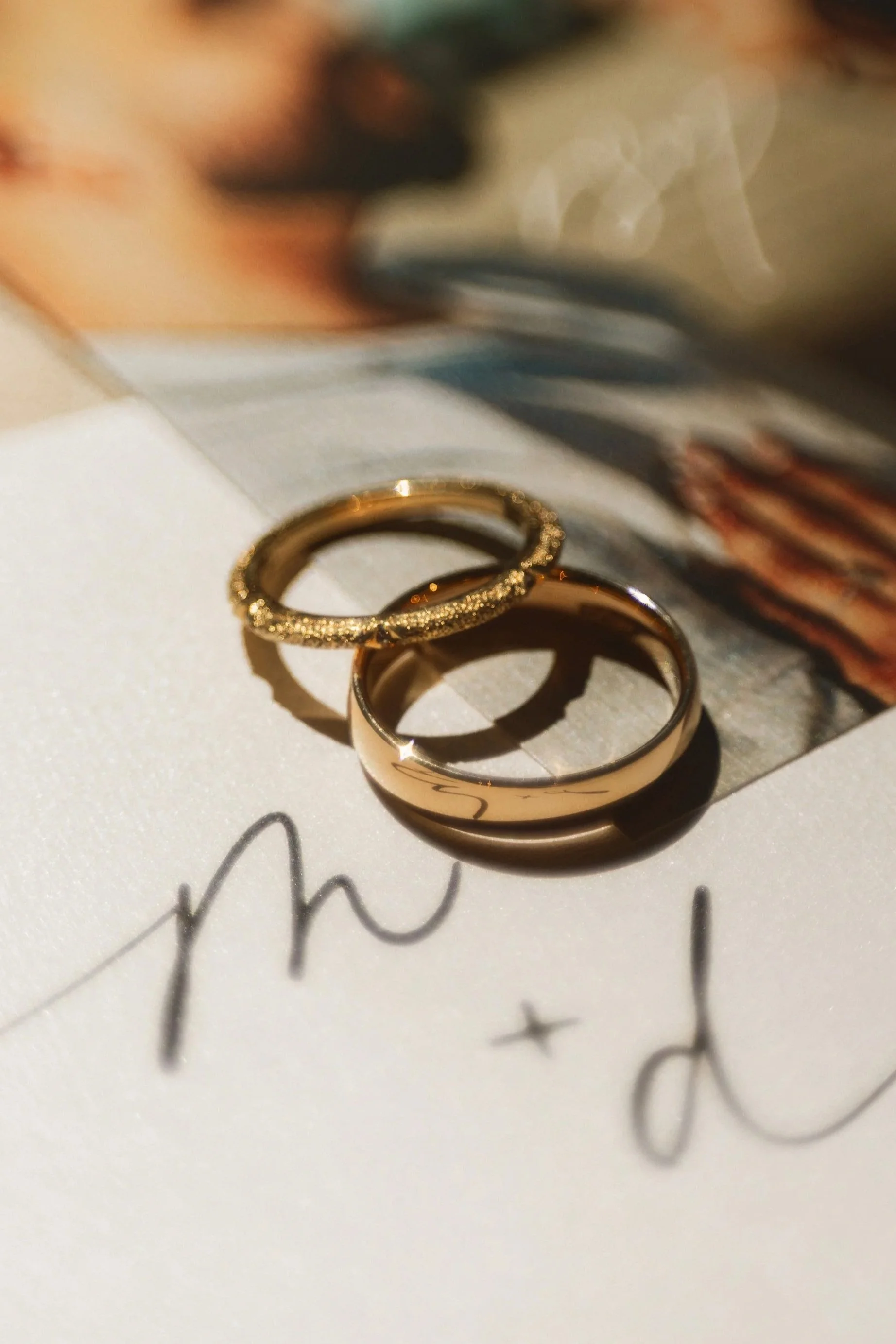 Close-up of wedding bands on top of Marvin and Diana’s invitation