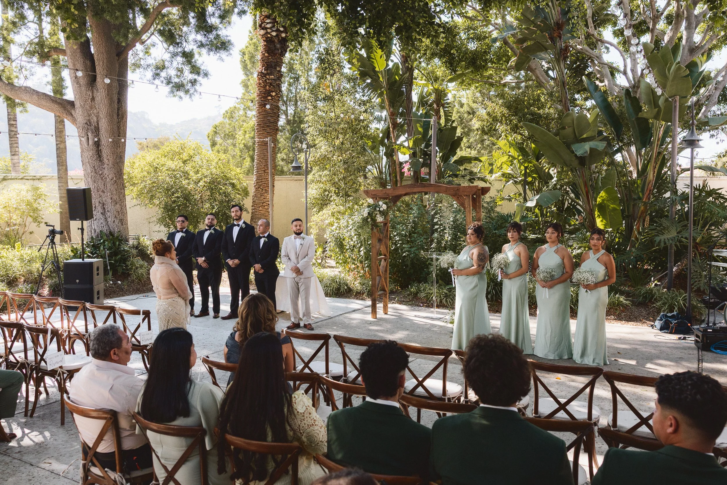 Bride and groom with wedding party during outdoor ceremony at Los Angeles River Center