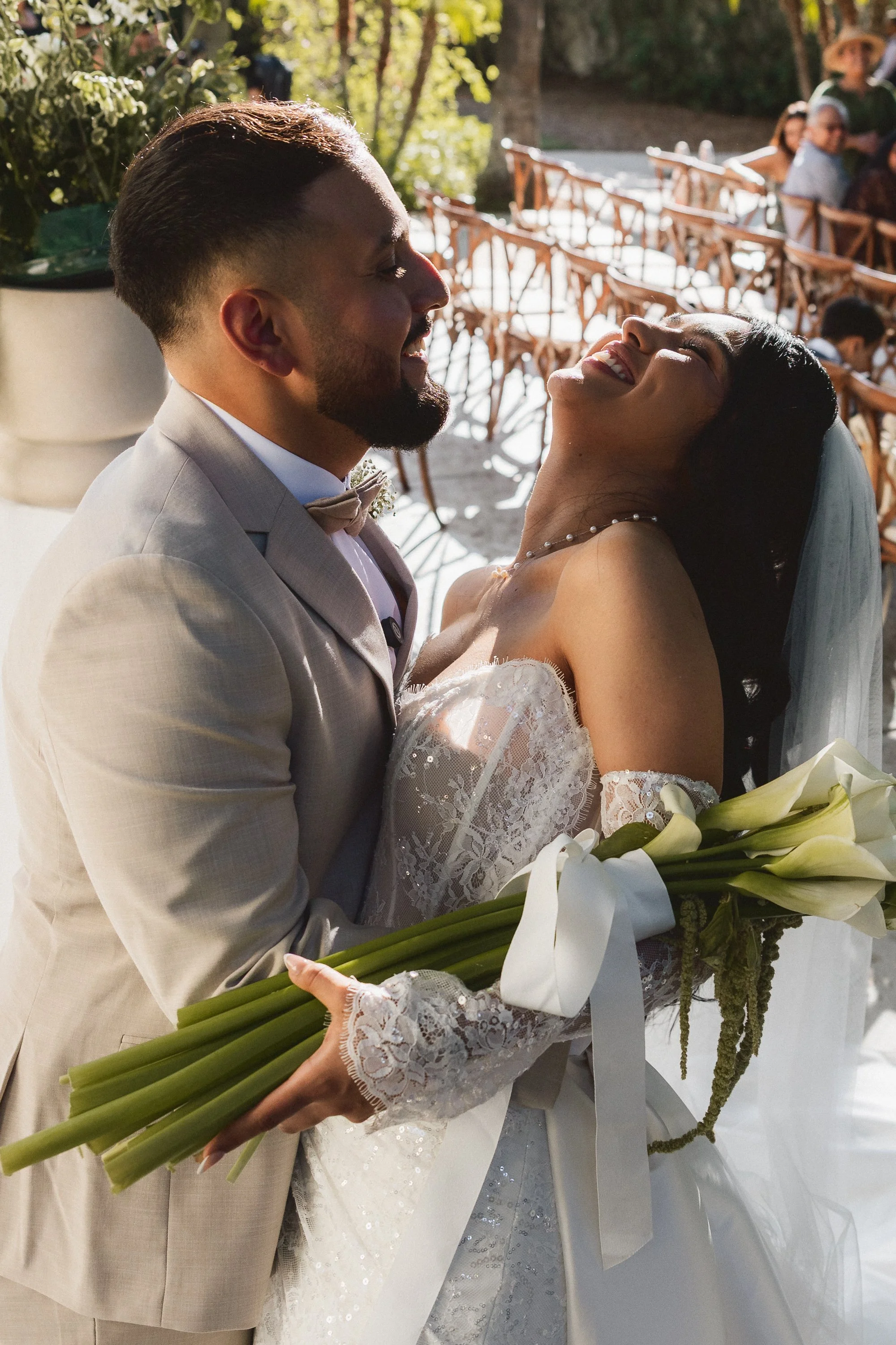 Bride and groom laughing and holding each other after ceremony at Los Angeles River Center and Gardens.