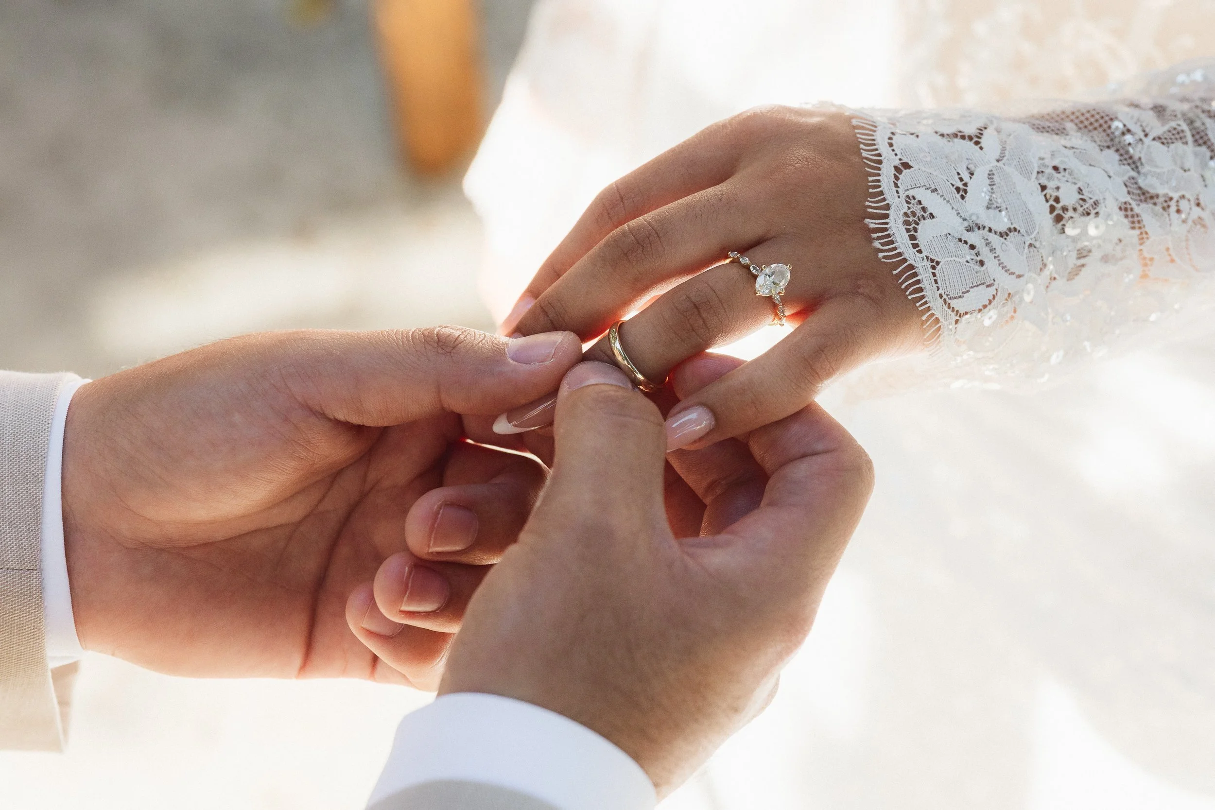 Groom placing wedding ring on bride’s hand at Los Angeles River Center and Gardens ceremony.