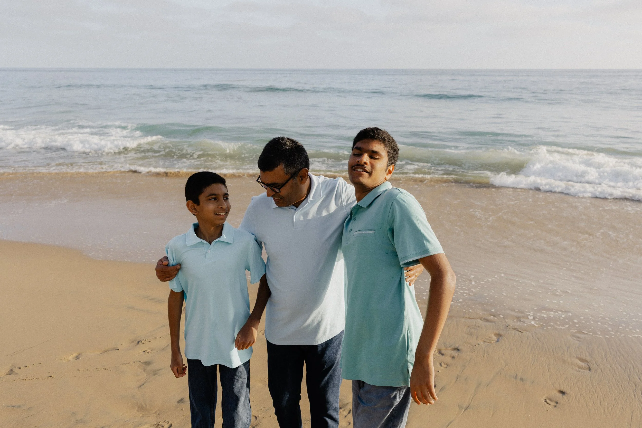 Father walking along the water with his two sons at Crystal Cove State Park in Orange County.