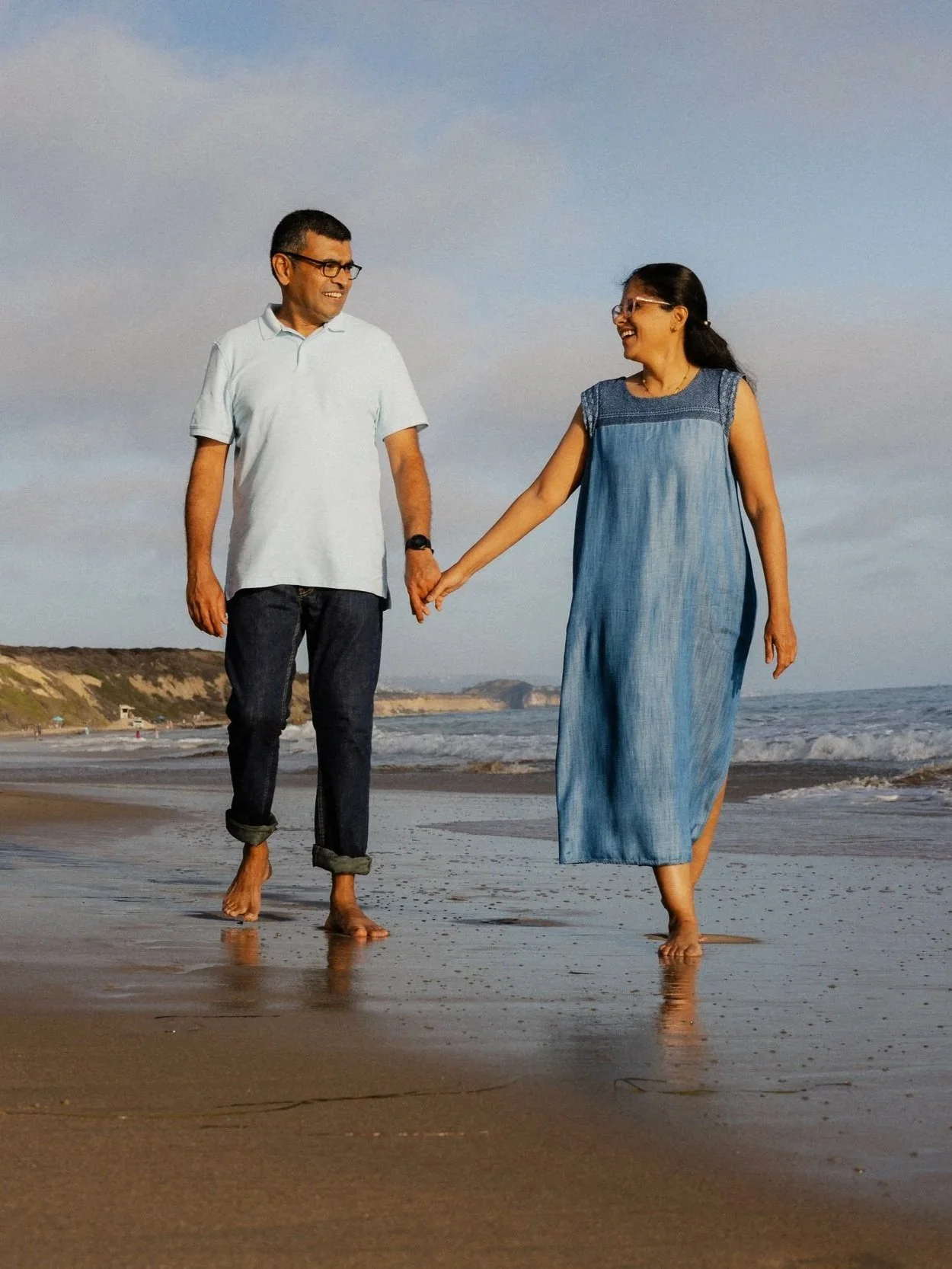 Couple walking hand in hand along the shoreline at Crystal Cove State Park in Orange County.