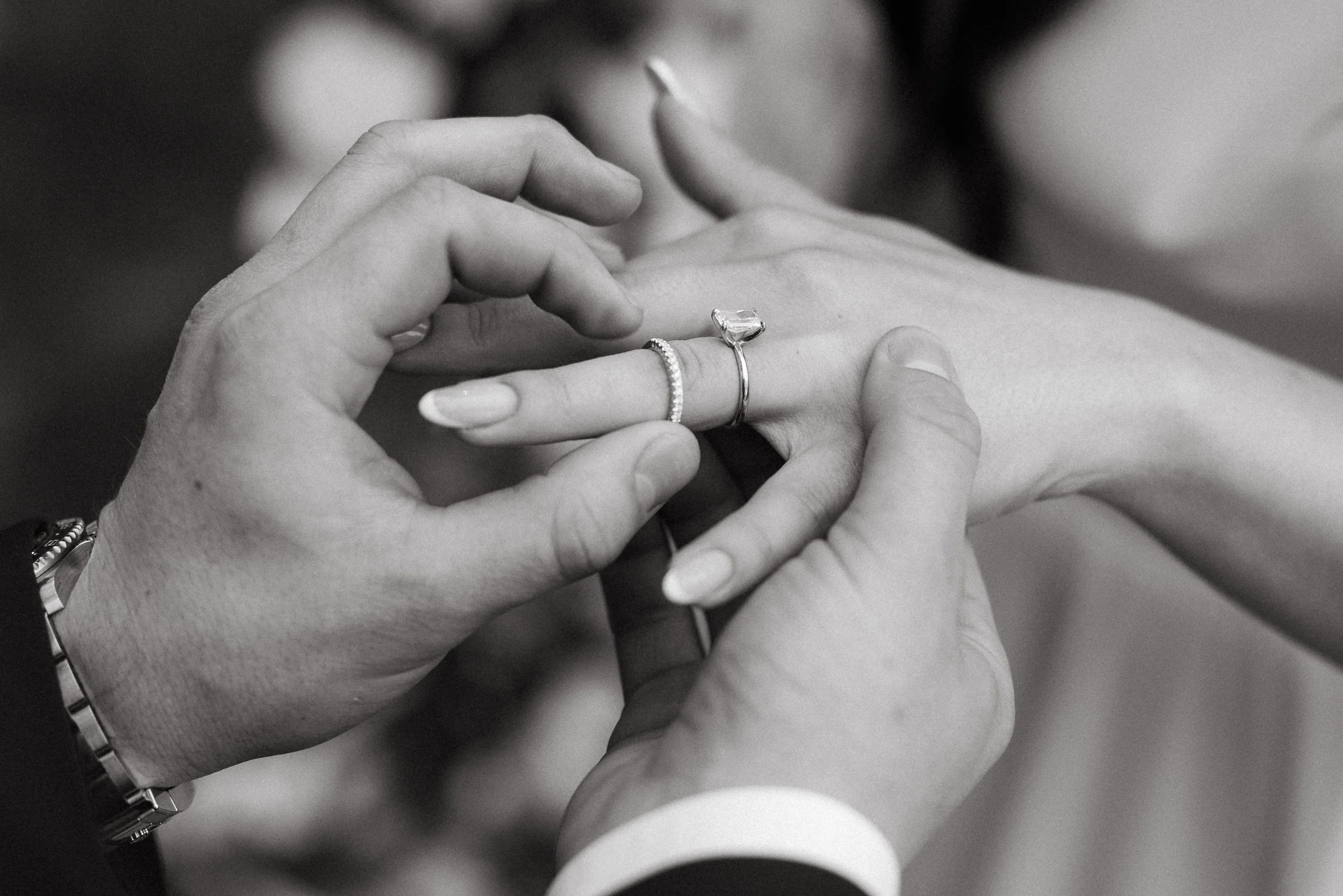 Emotional close-up of groom placing ring on bride’s finger.