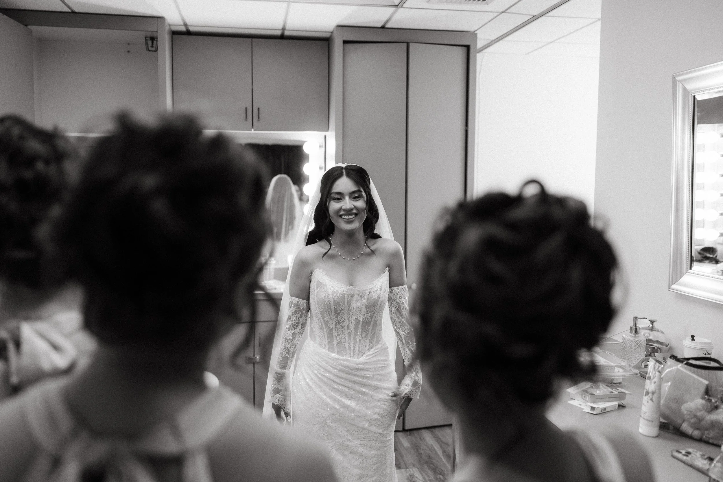 Bride smiling during emotional first look with bridesmaids