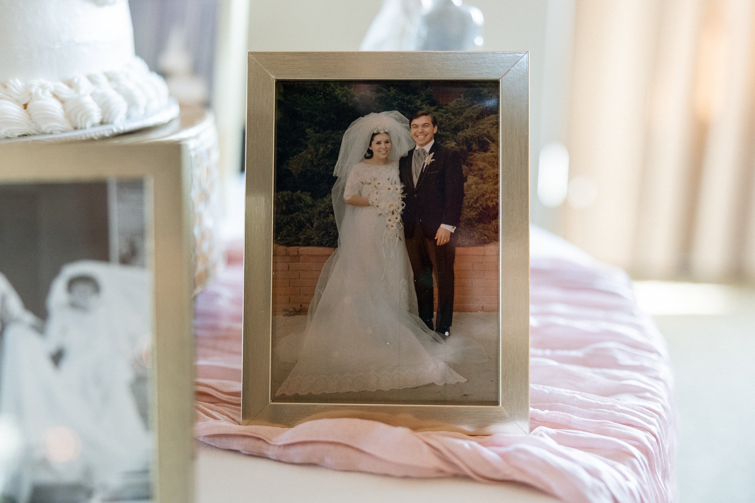 Vintage family wedding portrait framed and displayed near the cake table