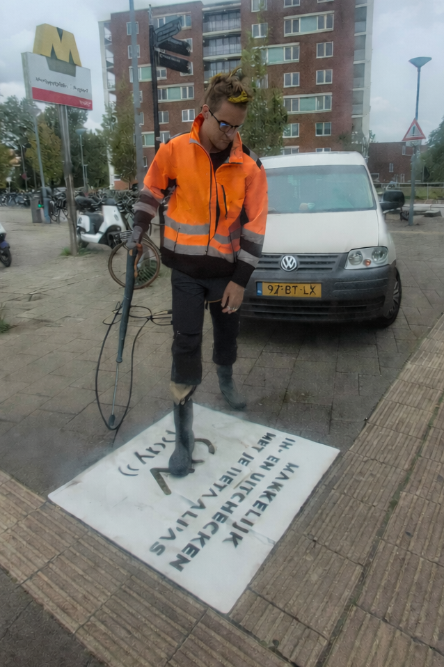 Uitvoerend medewerker van Promendus . Uitvoering van green graffiti ook bekend als clean advertisement, reverse graffiti,  stoepreclame van Promendus. Een unieke opmerkelijke Milieuvriendelijke vorm van straatreclame. guerilla advertising in actie.
