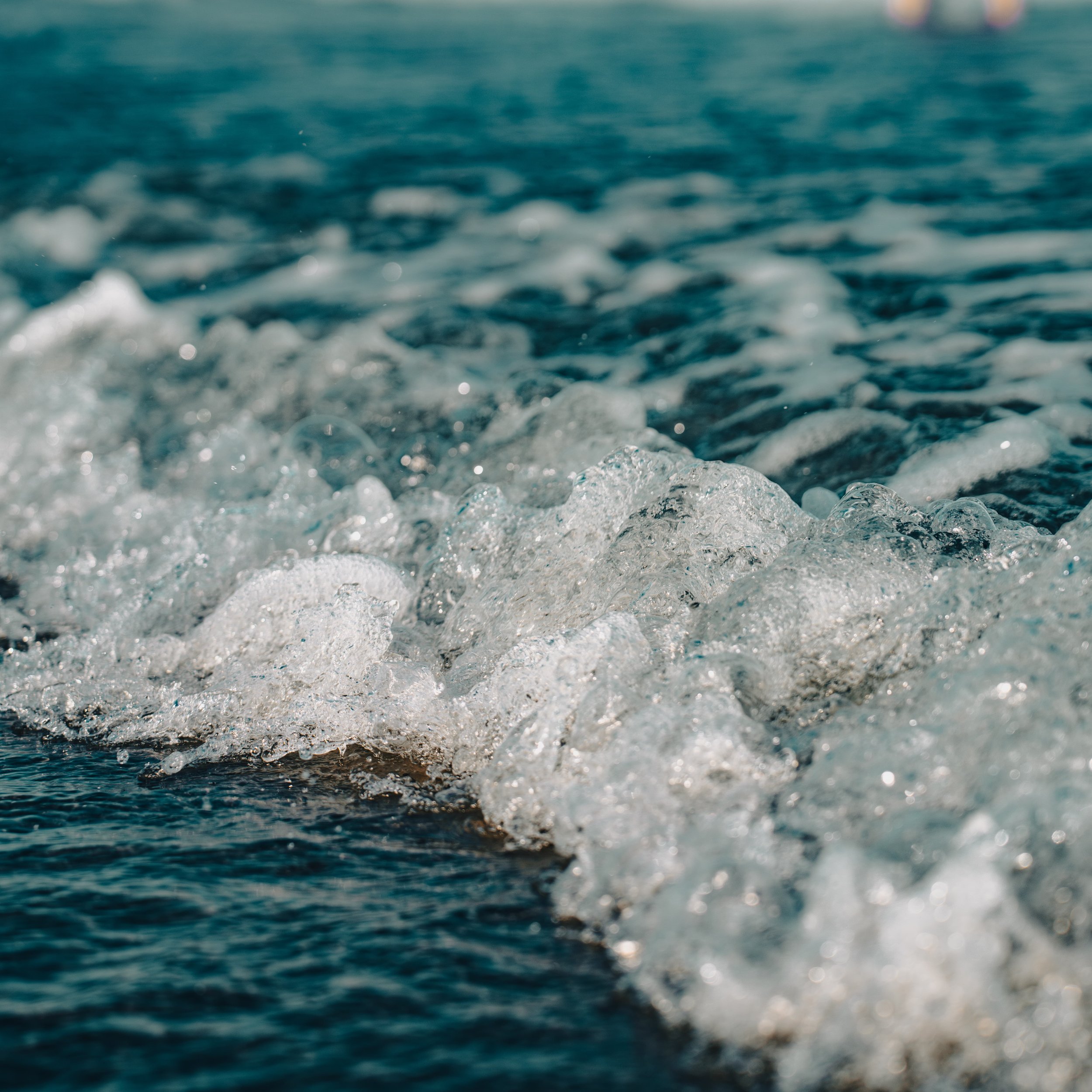 Close-up of ocean waves with white foam and blue water.