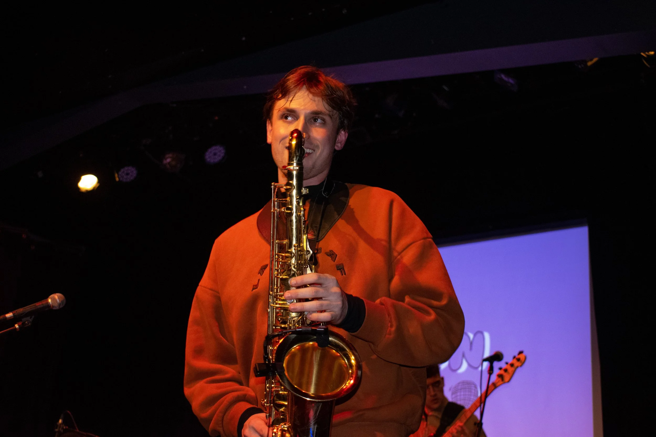 Evan Jacobson captivating an audience with a saxophone solo in a NYC jazz club.
