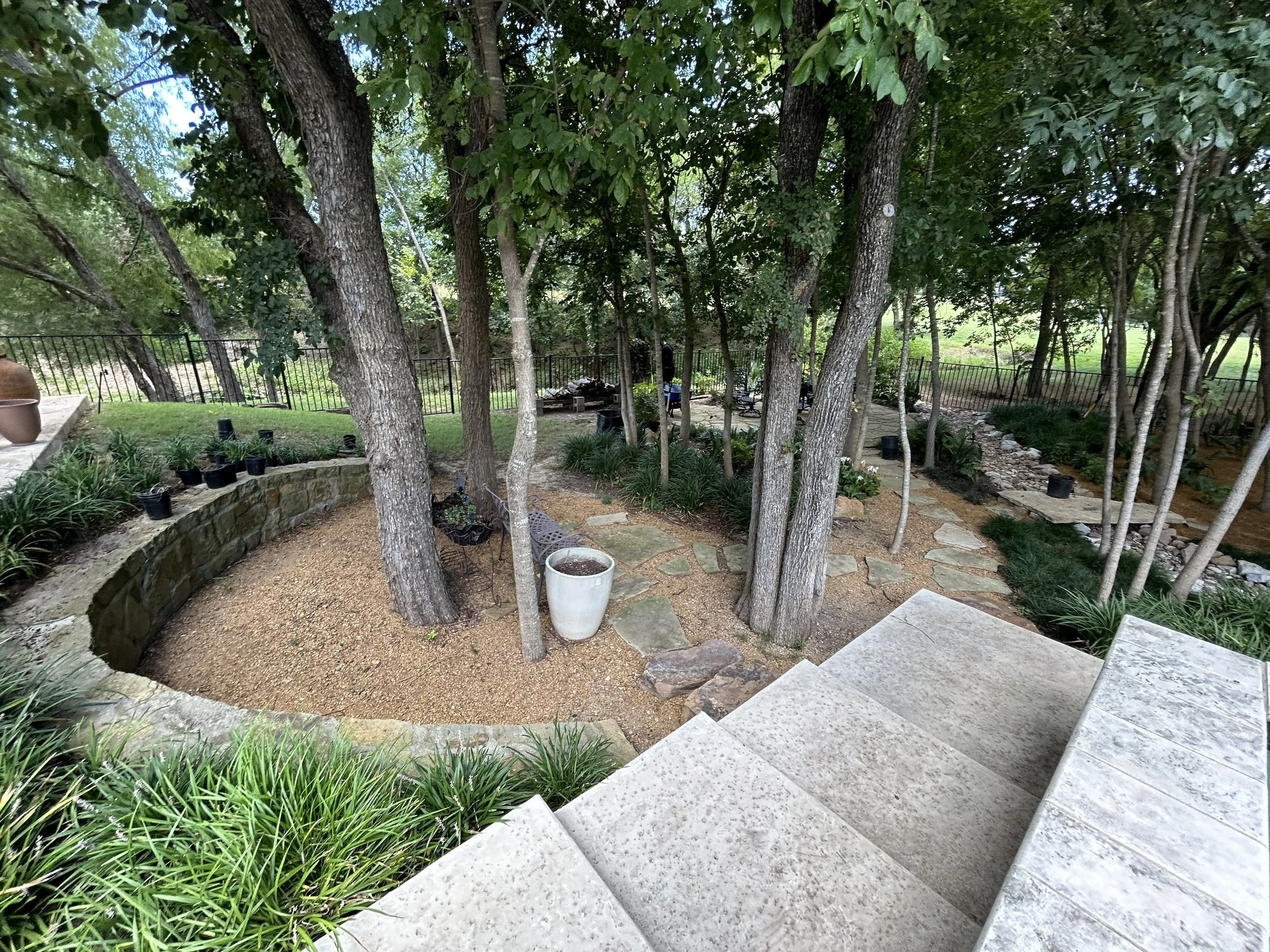 Photo showcasing the landscape installation of new plants, gravel, and stepstones for a more walkable area