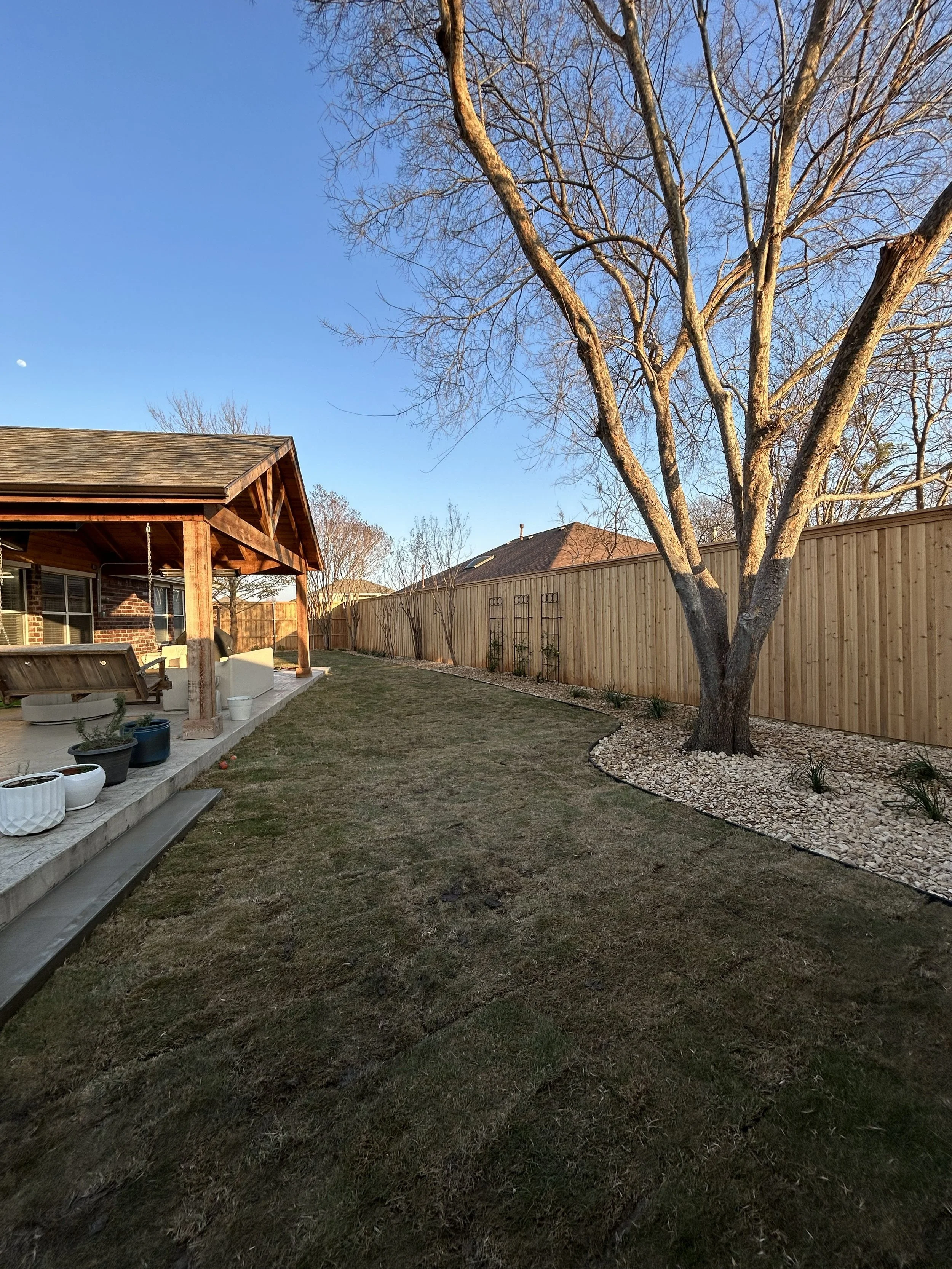 After photo of landscape installation with new gravel, grass, and plants