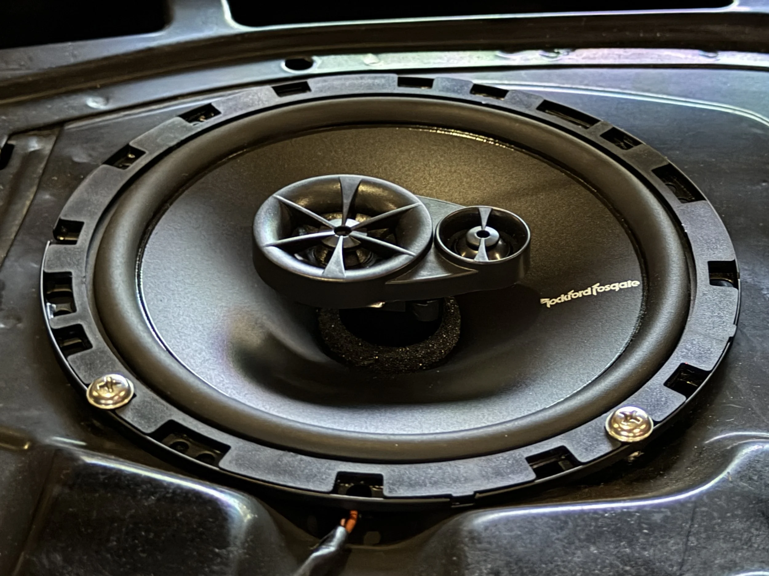 A close-up of a Blackford Fosgate car speaker with a burst design, installed in a vehicle's dashboard.