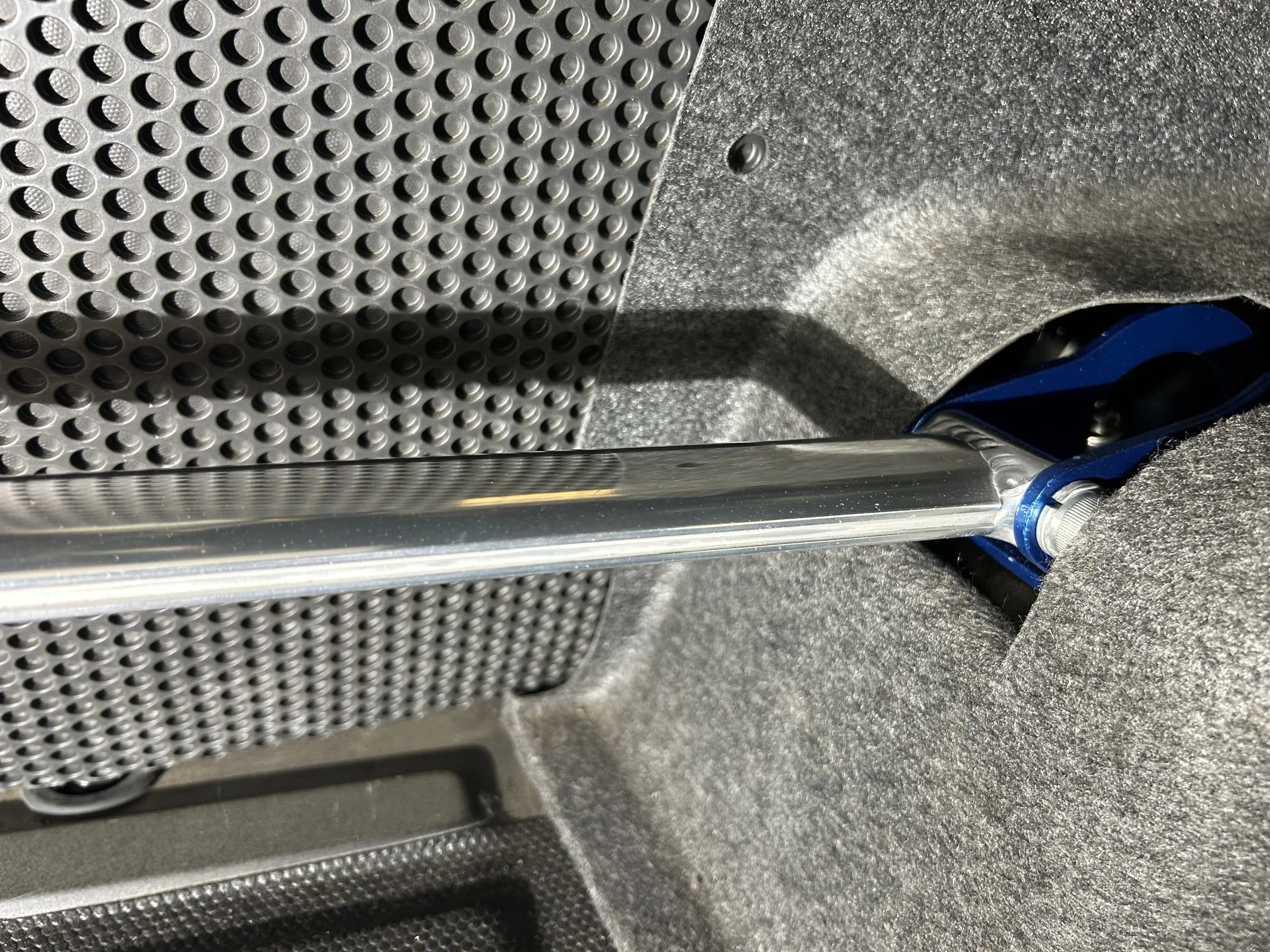 Close-up of a bicycle's front suspension fork mounted inside a car trunk.