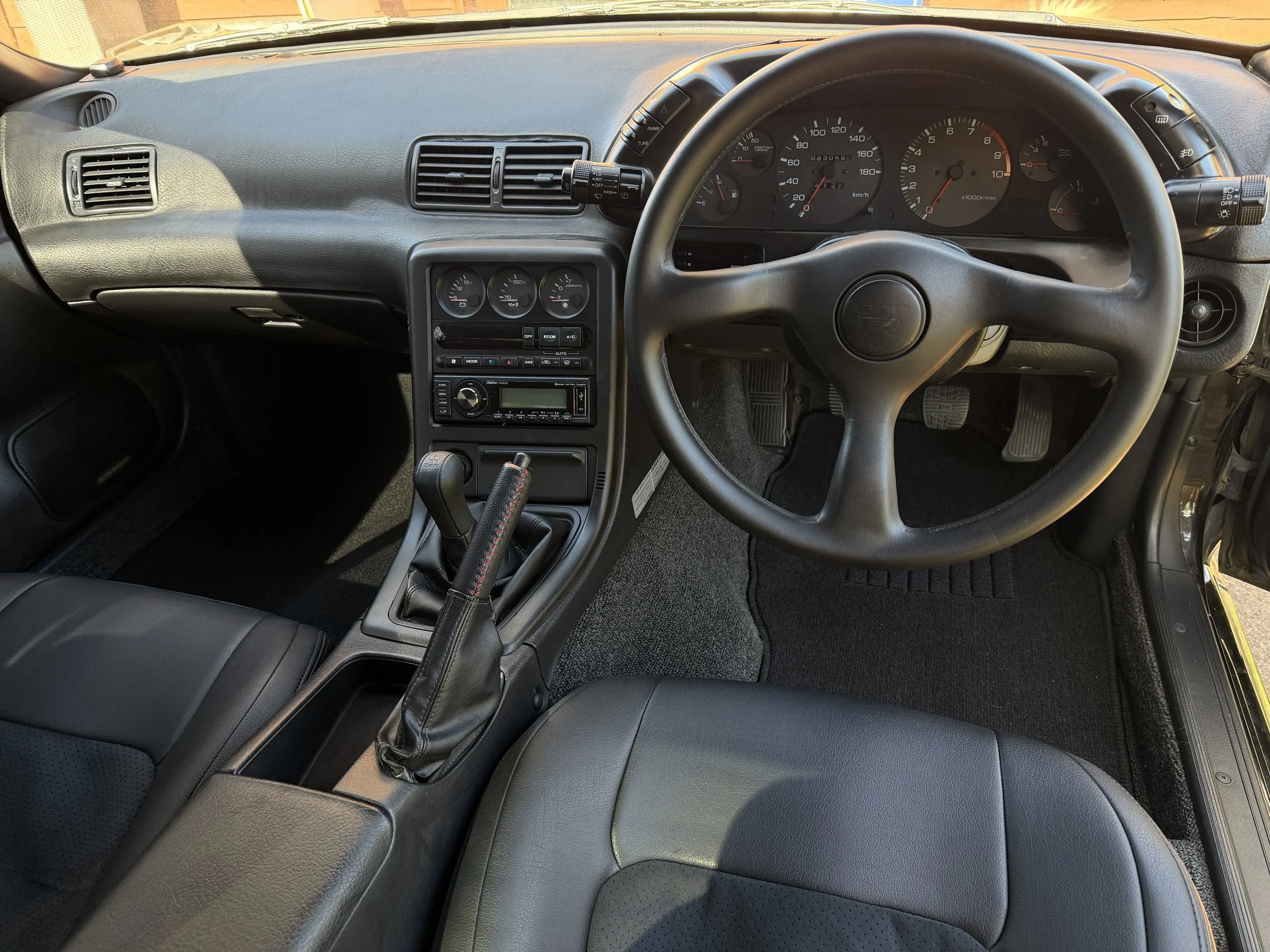 Interior of a car showing the dashboard, steering wheel, gear shift, and front seats