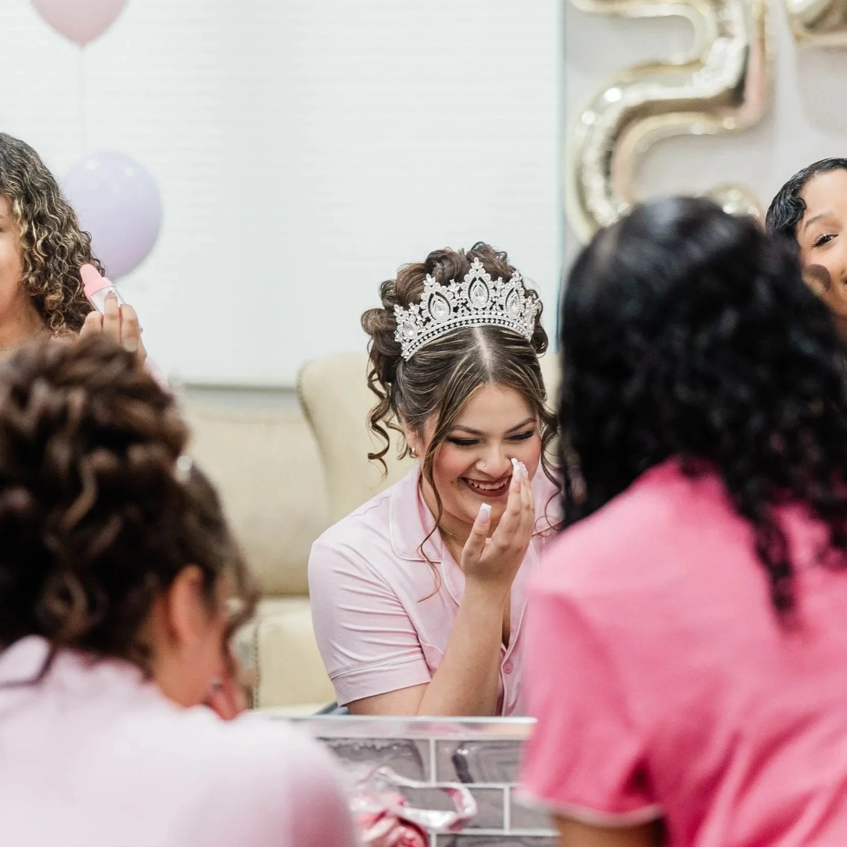 Group of girls talking and giggling while getting ready for her Quinceañera